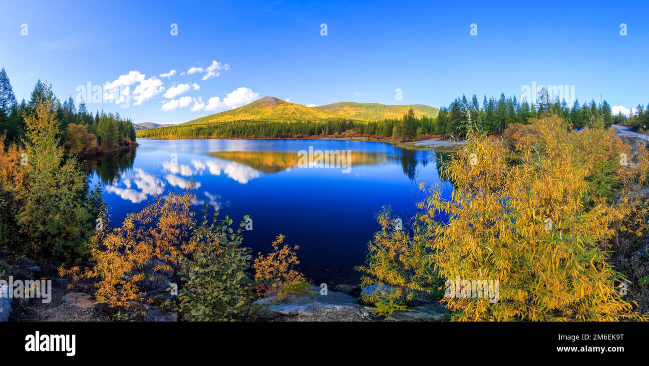 Prise de vue panoramique. Une belle surface plate du lac sur fond de collines colorées et le ciel bleu. Vue fascinante Banque D'Images