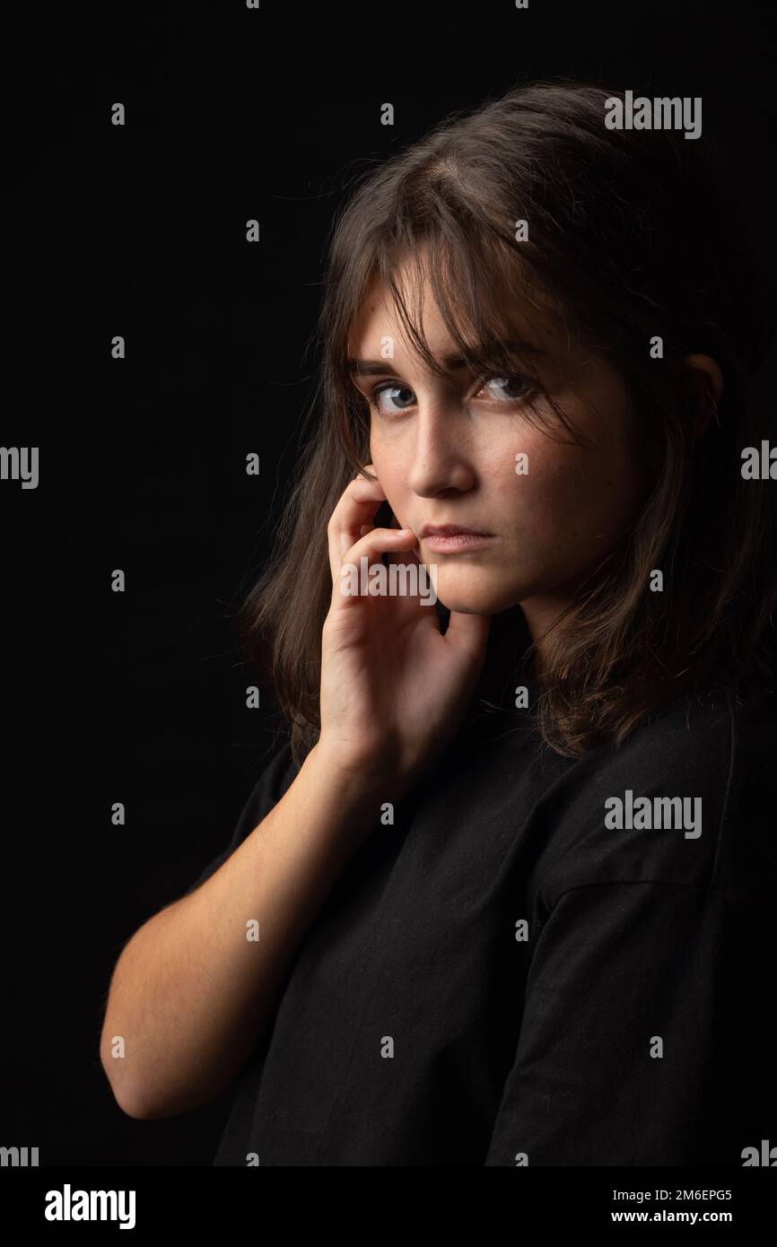 Beau portrait d'une jeune fille sur fond noir Banque D'Images