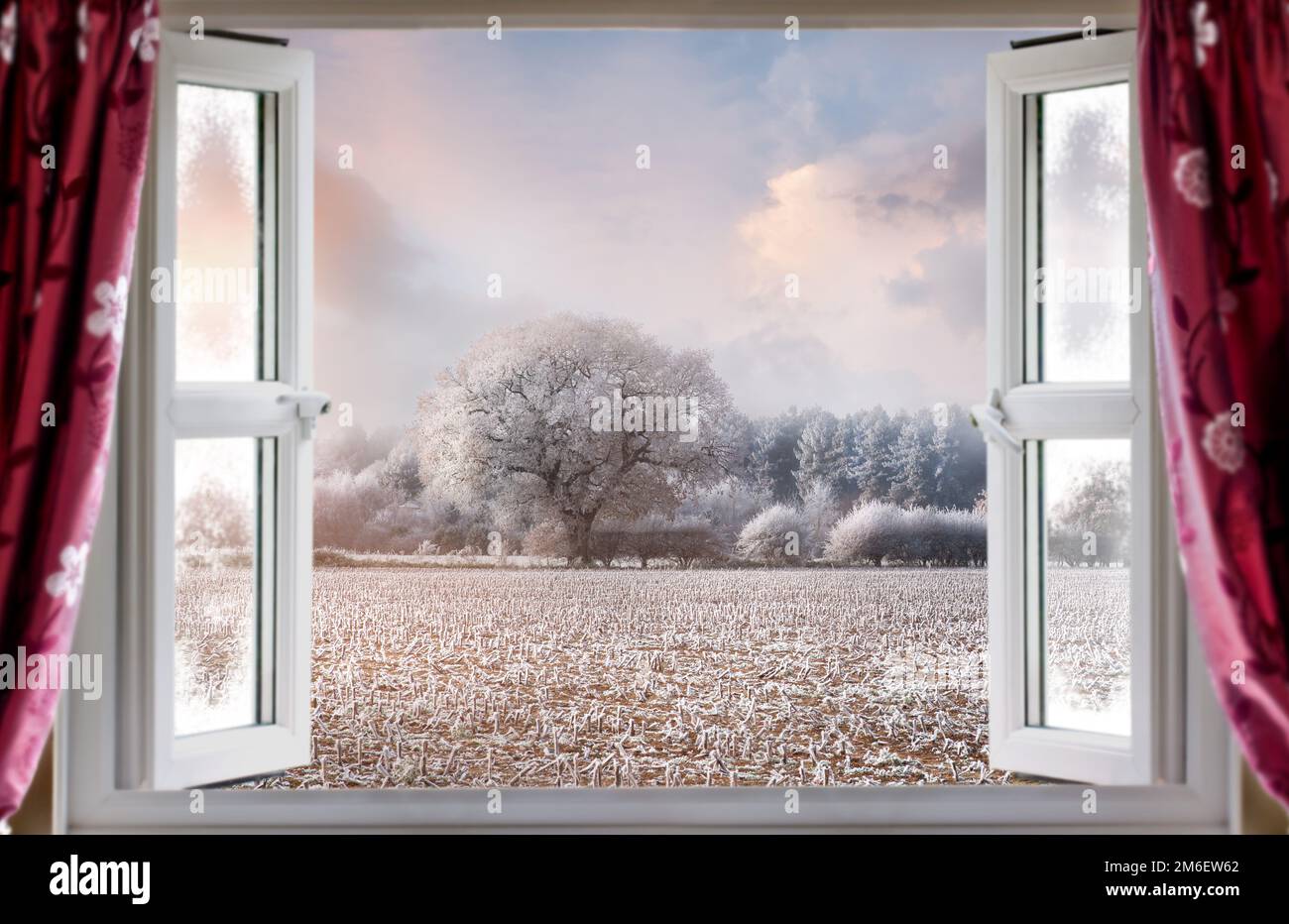 Vue à travers la fenêtre ouverte pour une vue magnifique sur le paysage rural d'hiver. Rideaux rouges et fenêtres modernes à double vitrage Banque D'Images