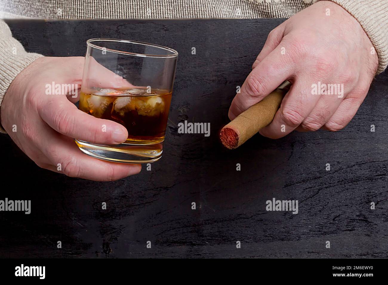 Mains d'hommes avec un cigare et un whisky Banque D'Images