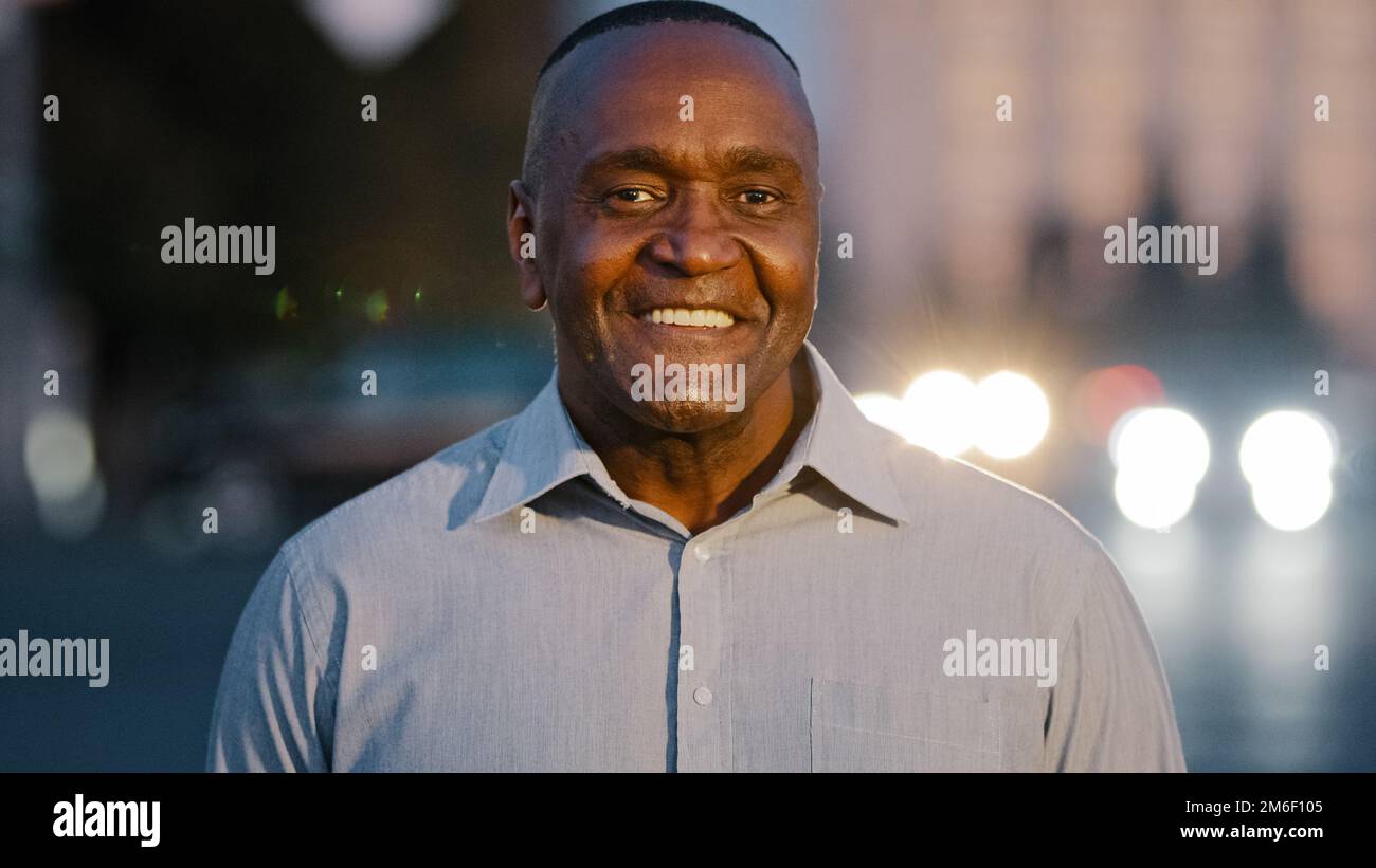 Gros plan portrait masculin en ville à l'extérieur afro-américain adulte d'âge moyen homme posant dans la rue sourire joyeux visage de type avec des rides réussi mûr Banque D'Images
