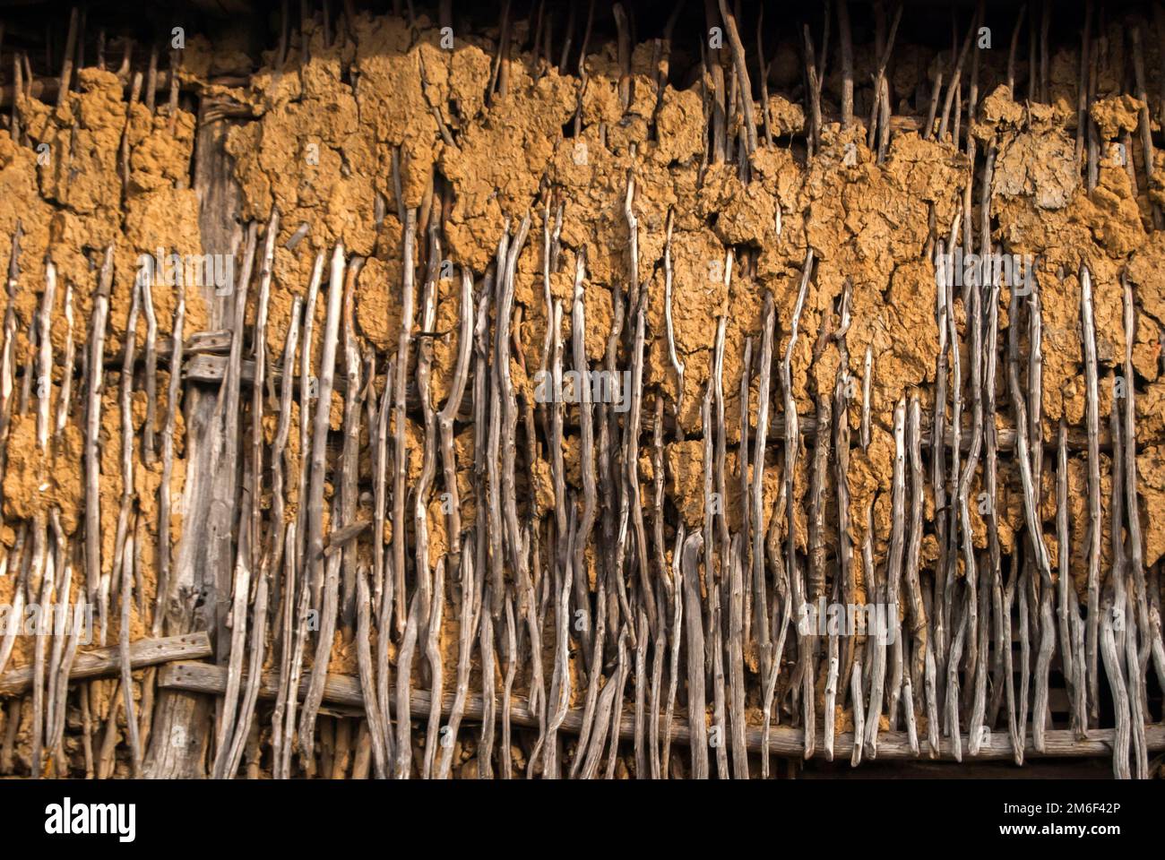 Mur en osier avec argile de l'ancienne ferme rurale de village gros plan sur fond rouillé Banque D'Images