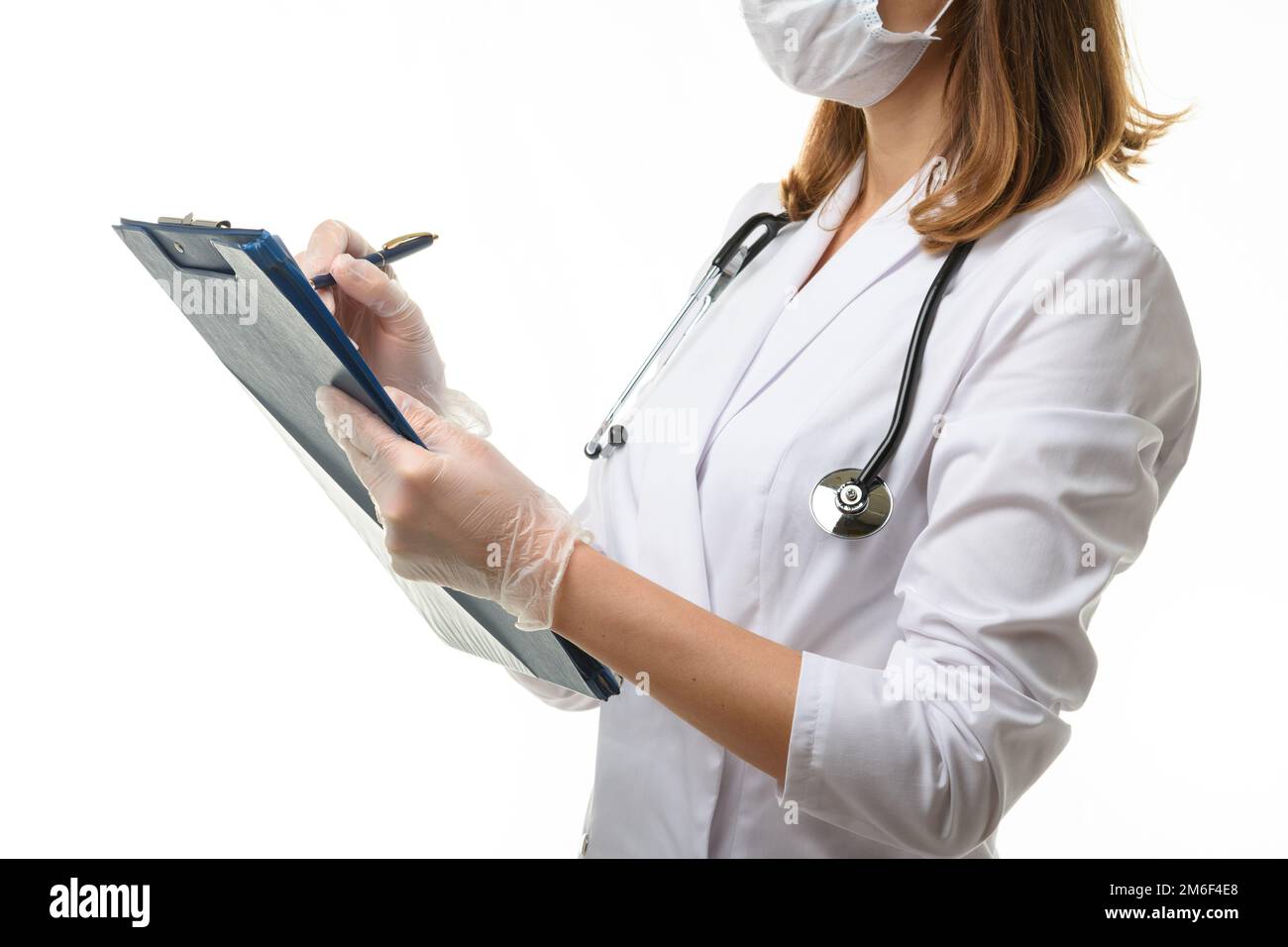 Le médecin écrit dans un presse-papiers avec un stylo à bille Banque D'Images