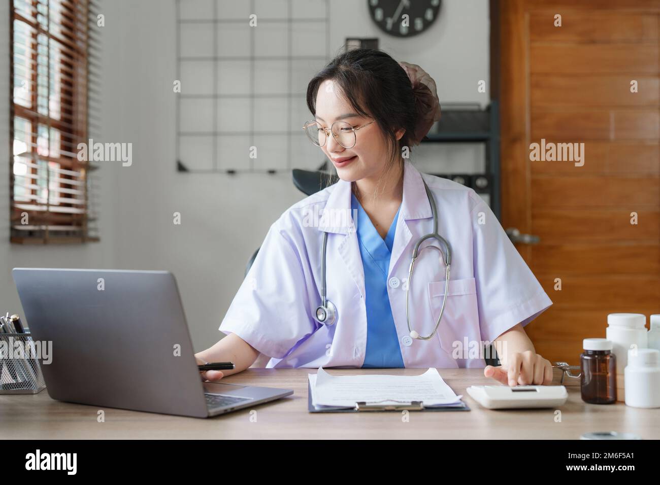 Portrait d'une femme médecin asiatique travaillant avec un document patient dans son bureau à la clinique Banque D'Images