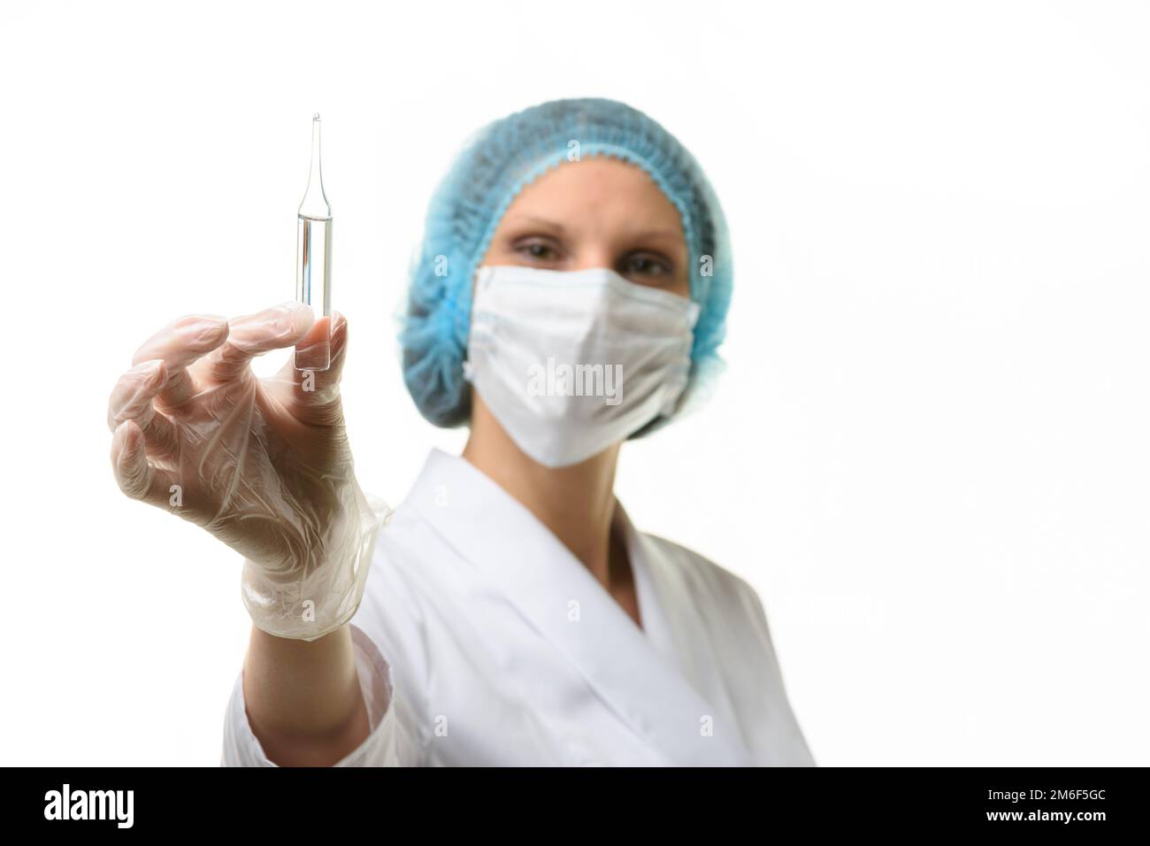 Fille médecin dans un masque médical tient une ampoule avec la médecine dans sa main Banque D'Images