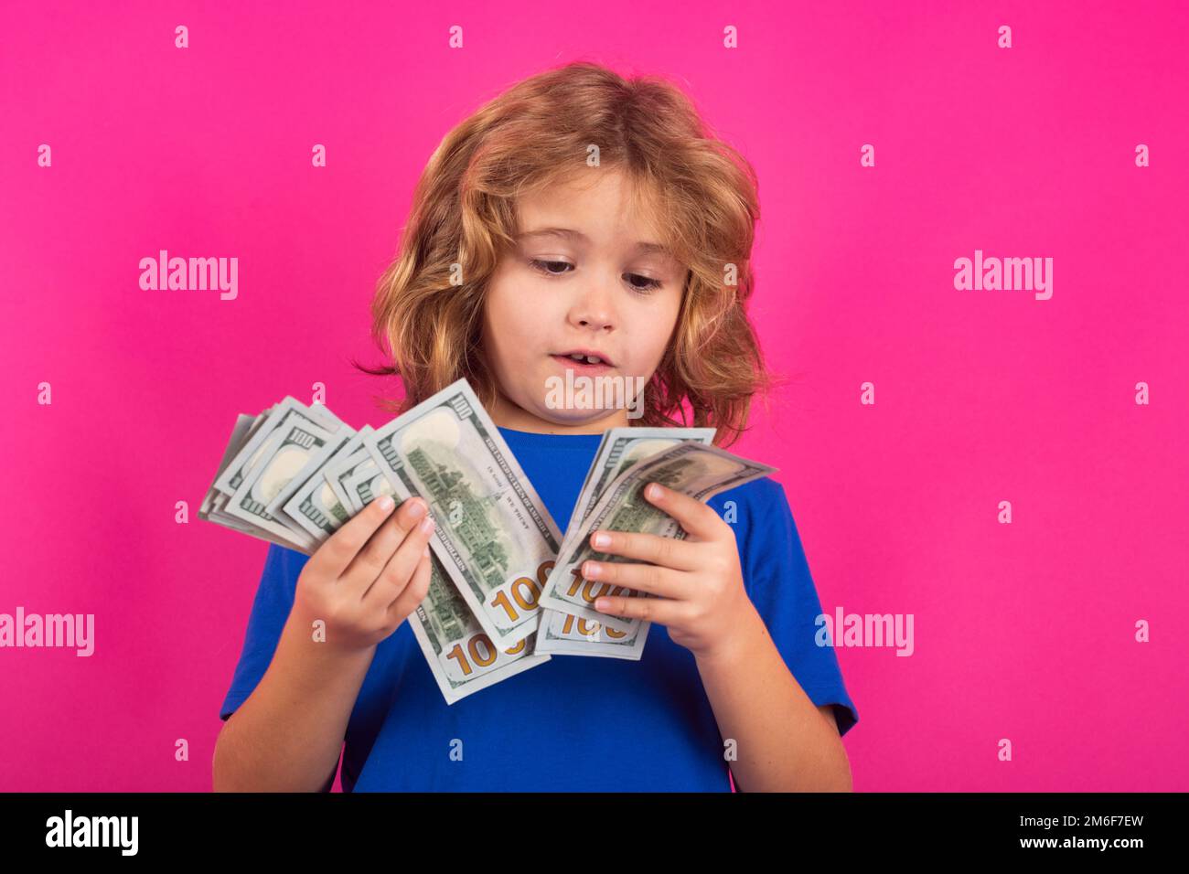Argent comptant en billets de banque en dollars. Enfant avec cent dollars d'argent isolé sur fond de studio. Banque D'Images