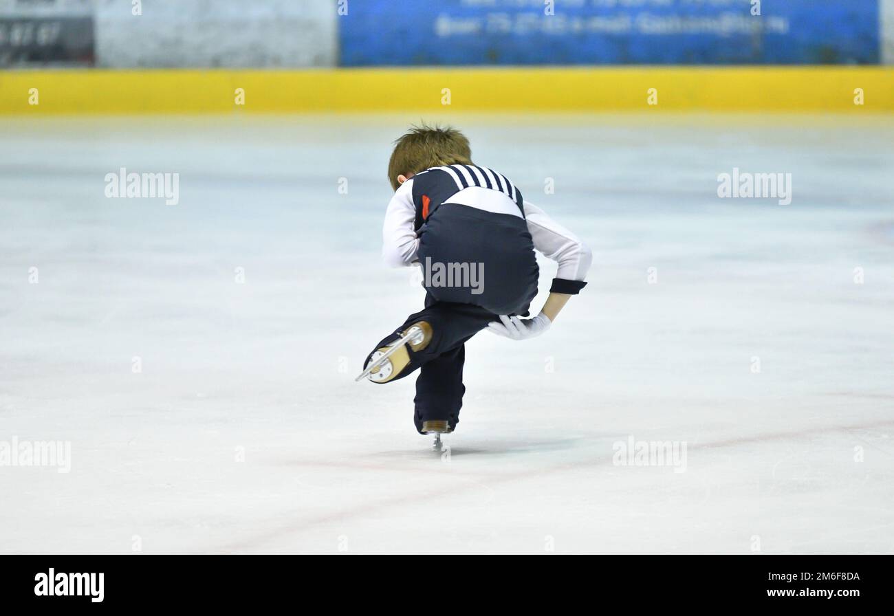 Le patinage artistique pour garçons roule sur une patinoire avec glace artificielle Banque D'Images