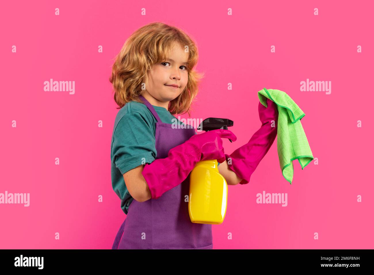 Un enfant nettoie à la maison. Nettoyage des enfants à l'aide d'une vadrouille pour faciliter les tâches ménagères. Petit garçon mignon balayant et nettoyant, isolé sur fond de couleur studio Banque D'Images