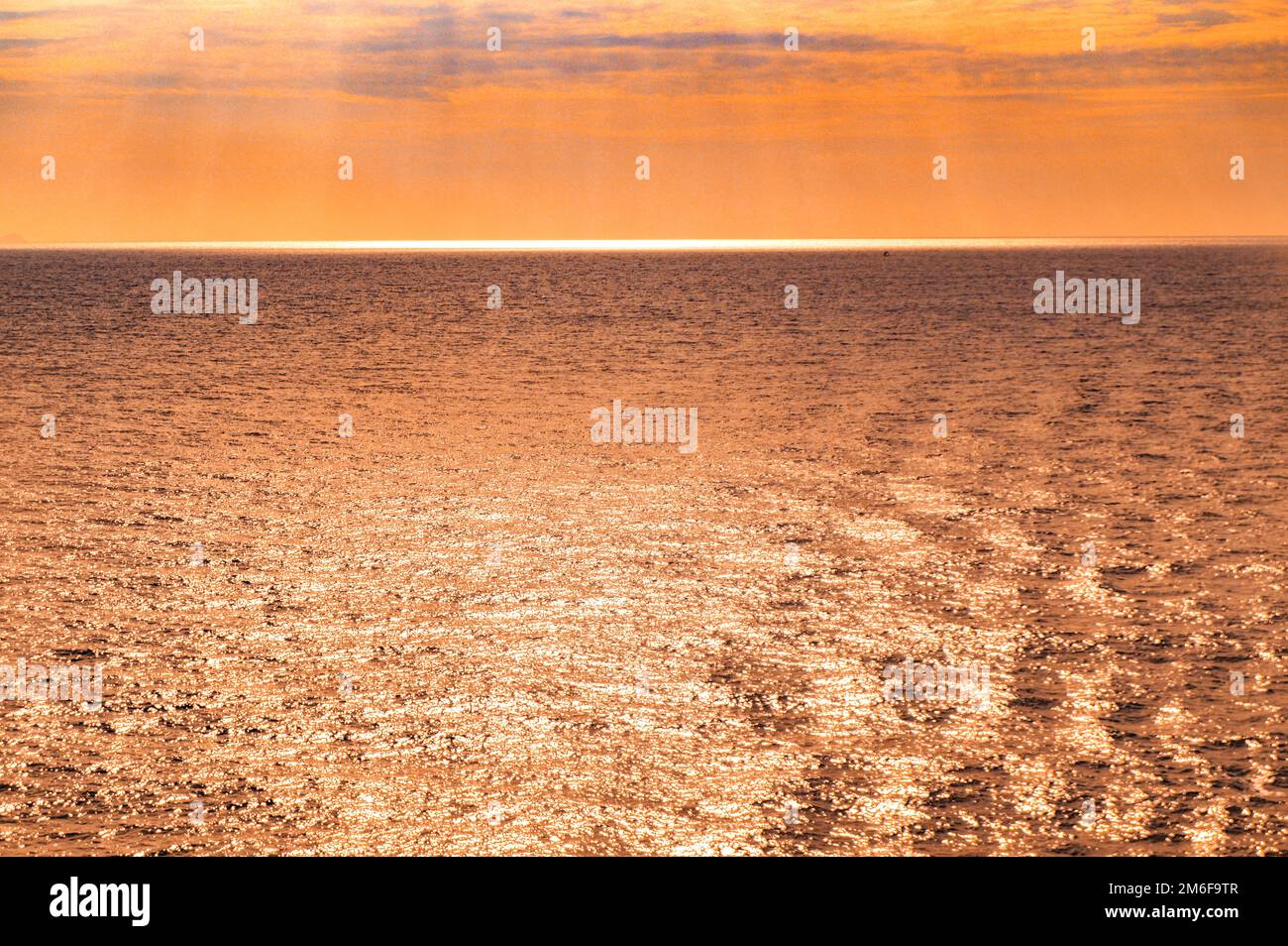 Coucher de soleil orange sur la mer, lumière du soleil sur la surface de l'eau de mer, lumière dorée et argentée magique, fantastique su naturel Banque D'Images