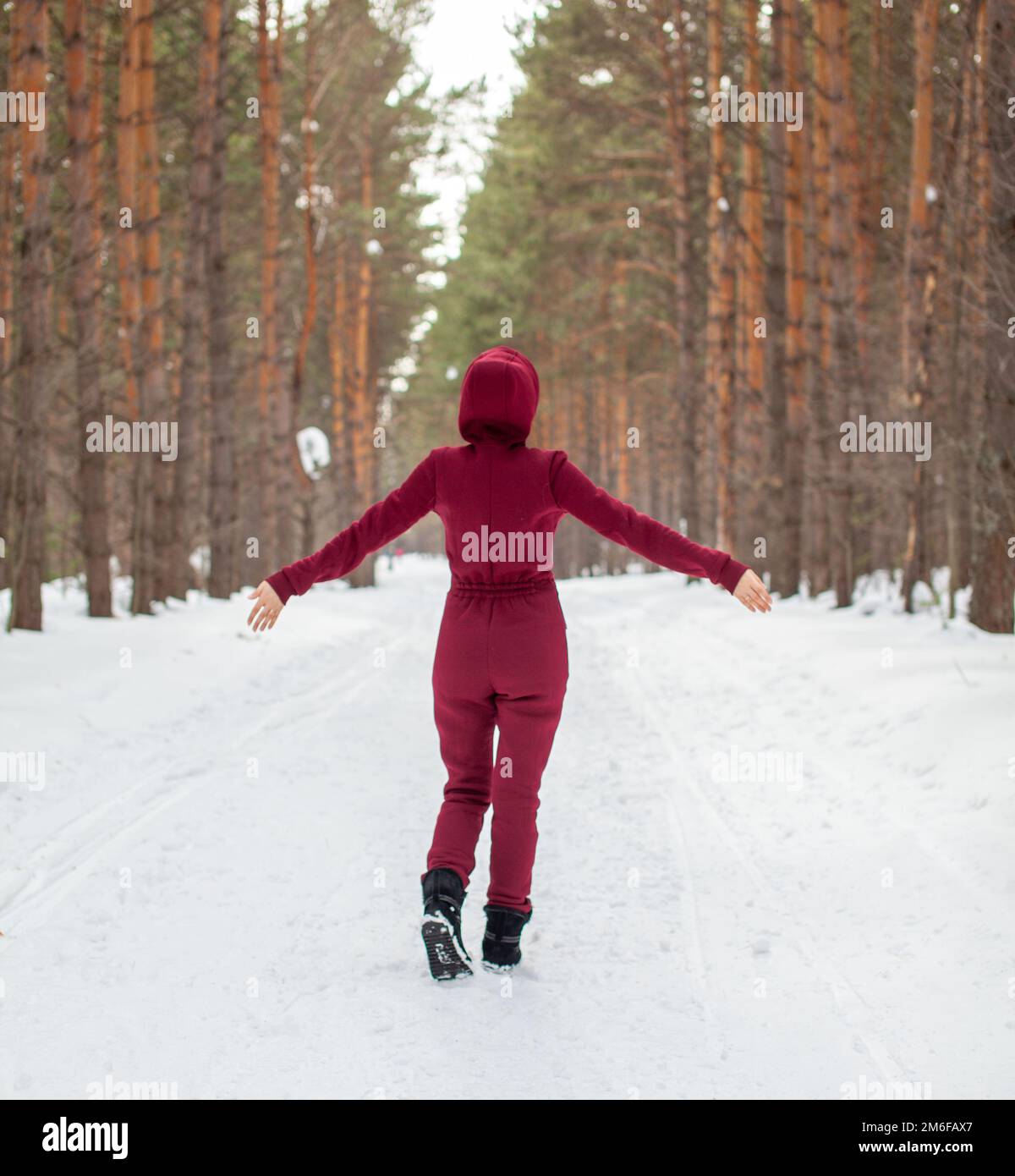 Promenade d'hiver dans une forêt enneigée, Une fille avec une combinaison rouge Banque D'Images
