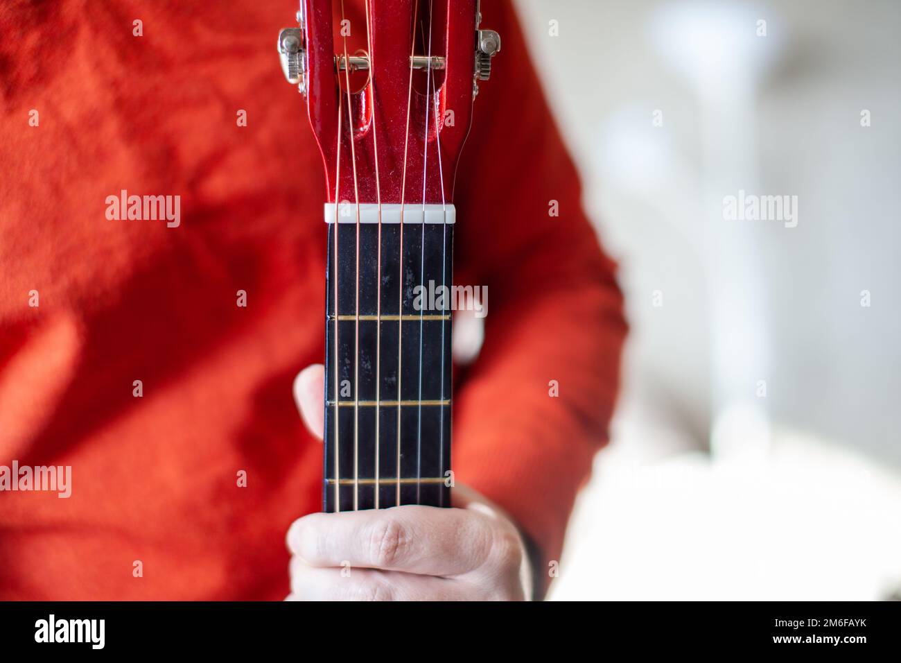 Gros plan d'un joueur de guitare ou d'une personne apprenant à jouer de la guitare. Banque D'Images