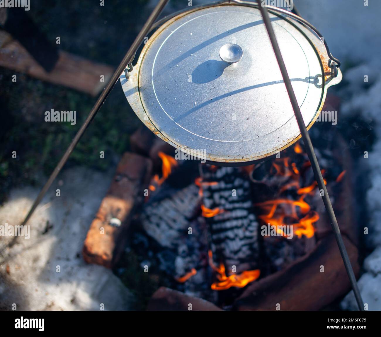 Au-dessus du feu est accroché un pot dans lequel cuire les aliments. Banque D'Images