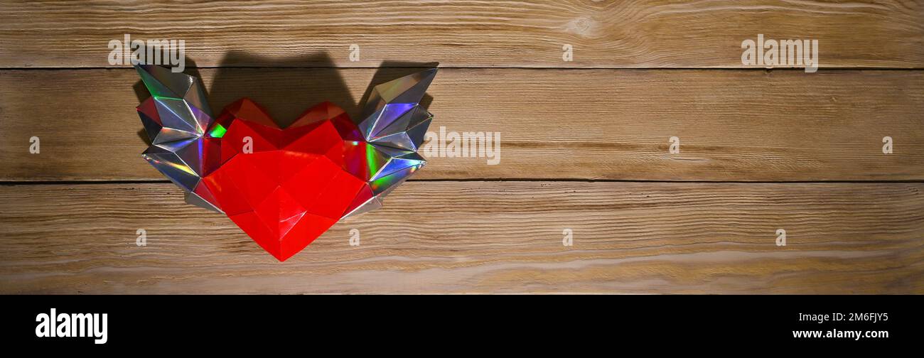 coeur sur fond en bois. une bannière avec un coeur rouge polygonal. copier l'espace Banque D'Images