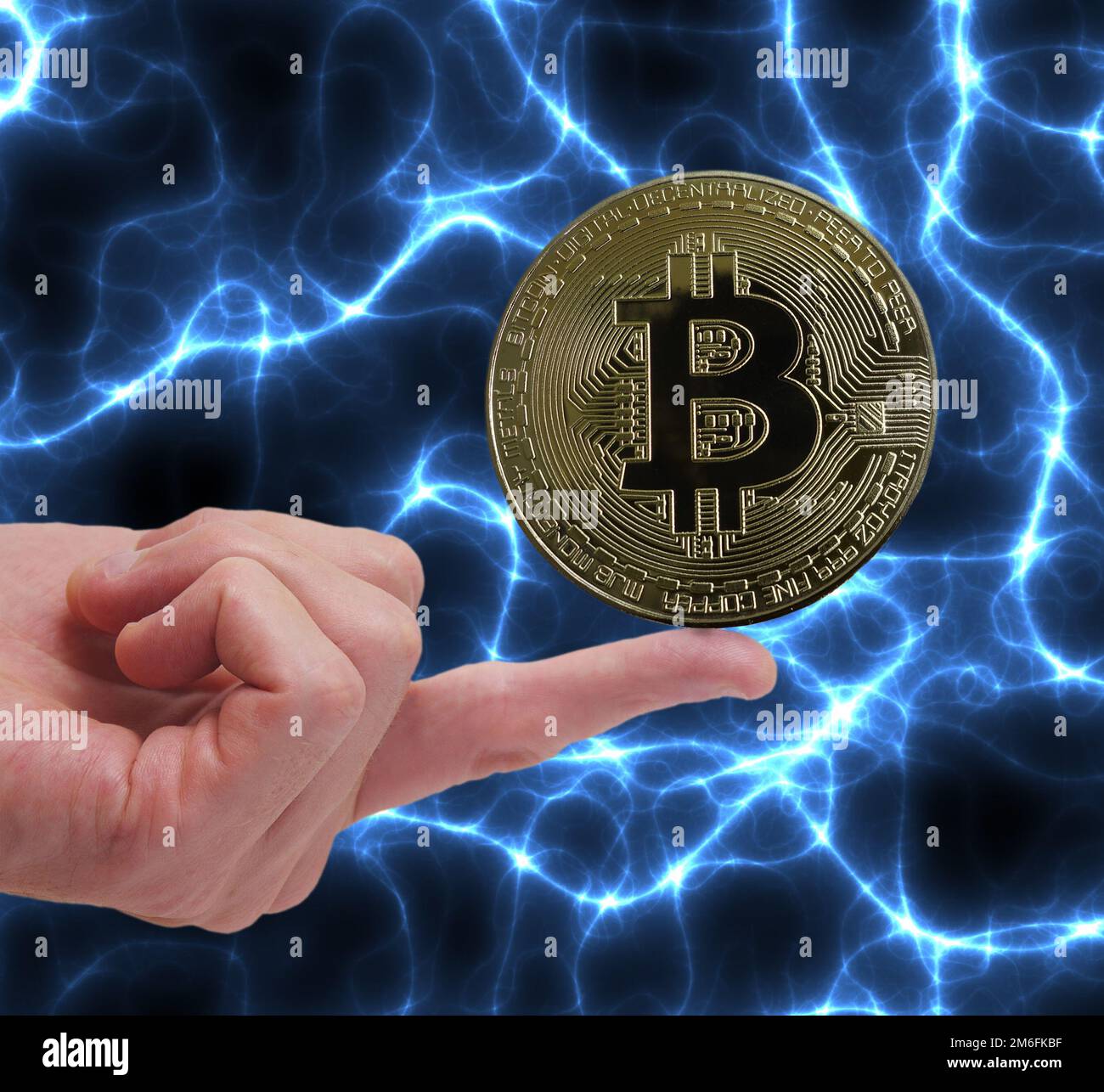 Bitcoin crypto-monnaie d'équilibrage de pièce sur un doigt avec fond bleu d'électricité Banque D'Images