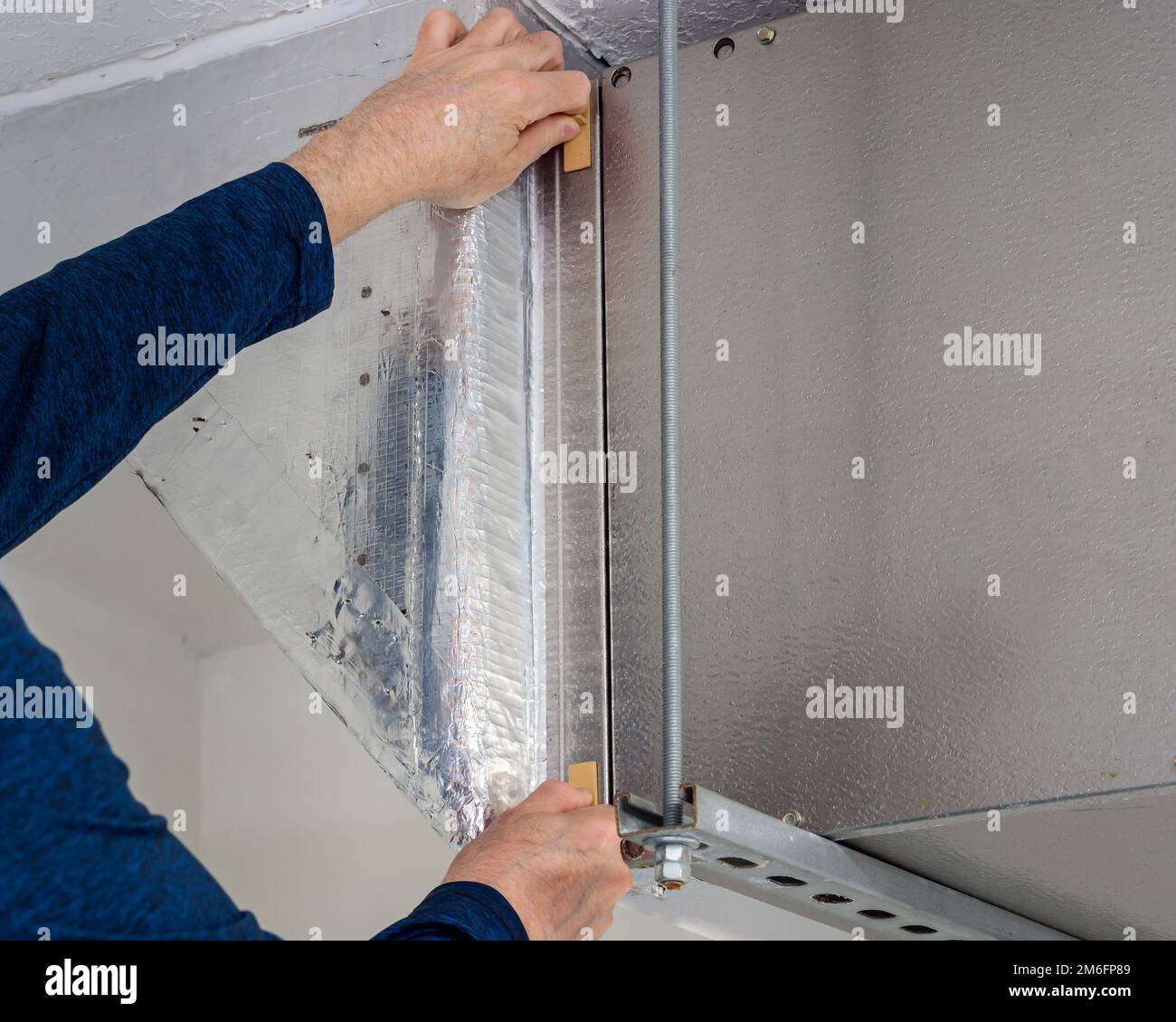 Un technicien d'entretien HVAC change le filtre à air intérieur sale dans le système de chauffage et de climatisation résidentiel. Entretien du système de ventilation de conduit d'air domestique Banque D'Images