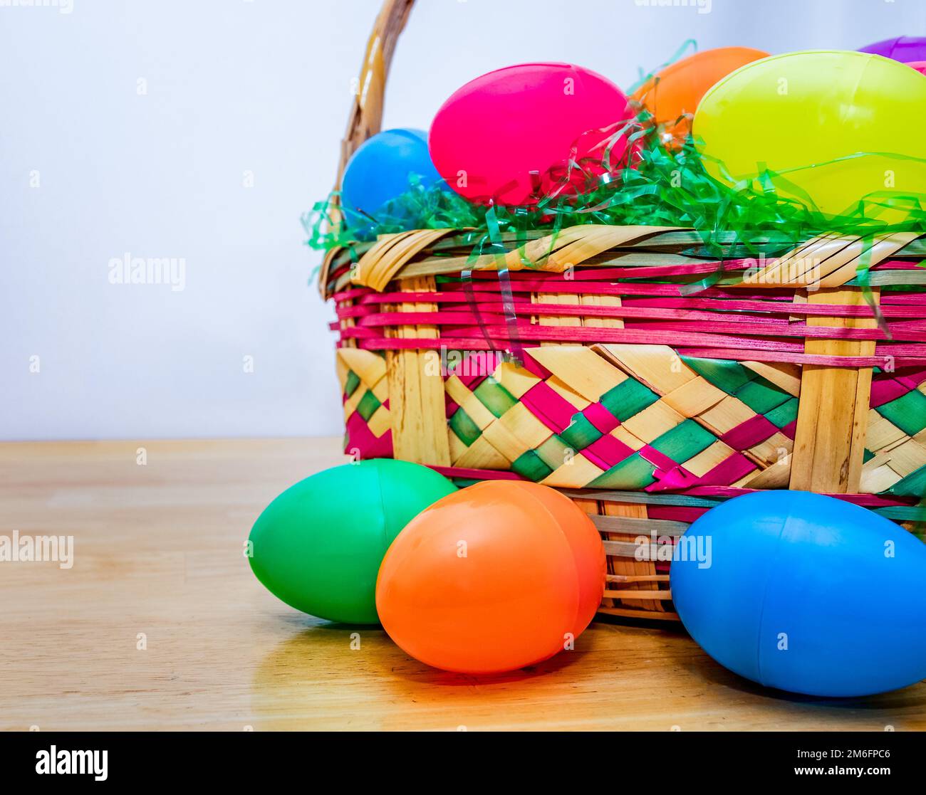 Panier de Pâques en osier avec œufs de Pâques en plastique coloré vintage. Banque D'Images