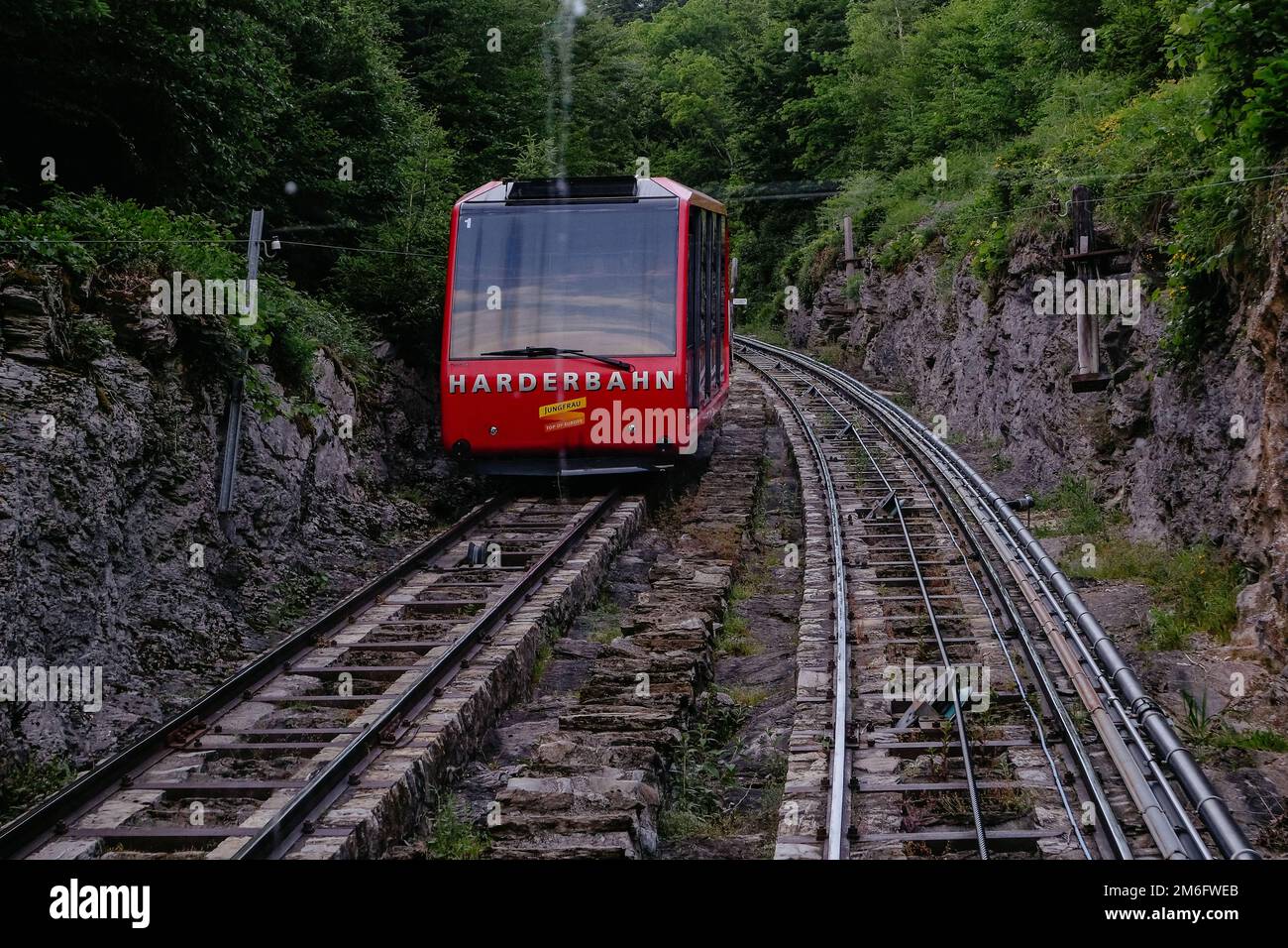 Train funiculaire rouge descendant de Harder Kulm, au sommet d'Interlaken. Le funiculaire conduit les touristes de haut en bas de la vie populaire Banque D'Images