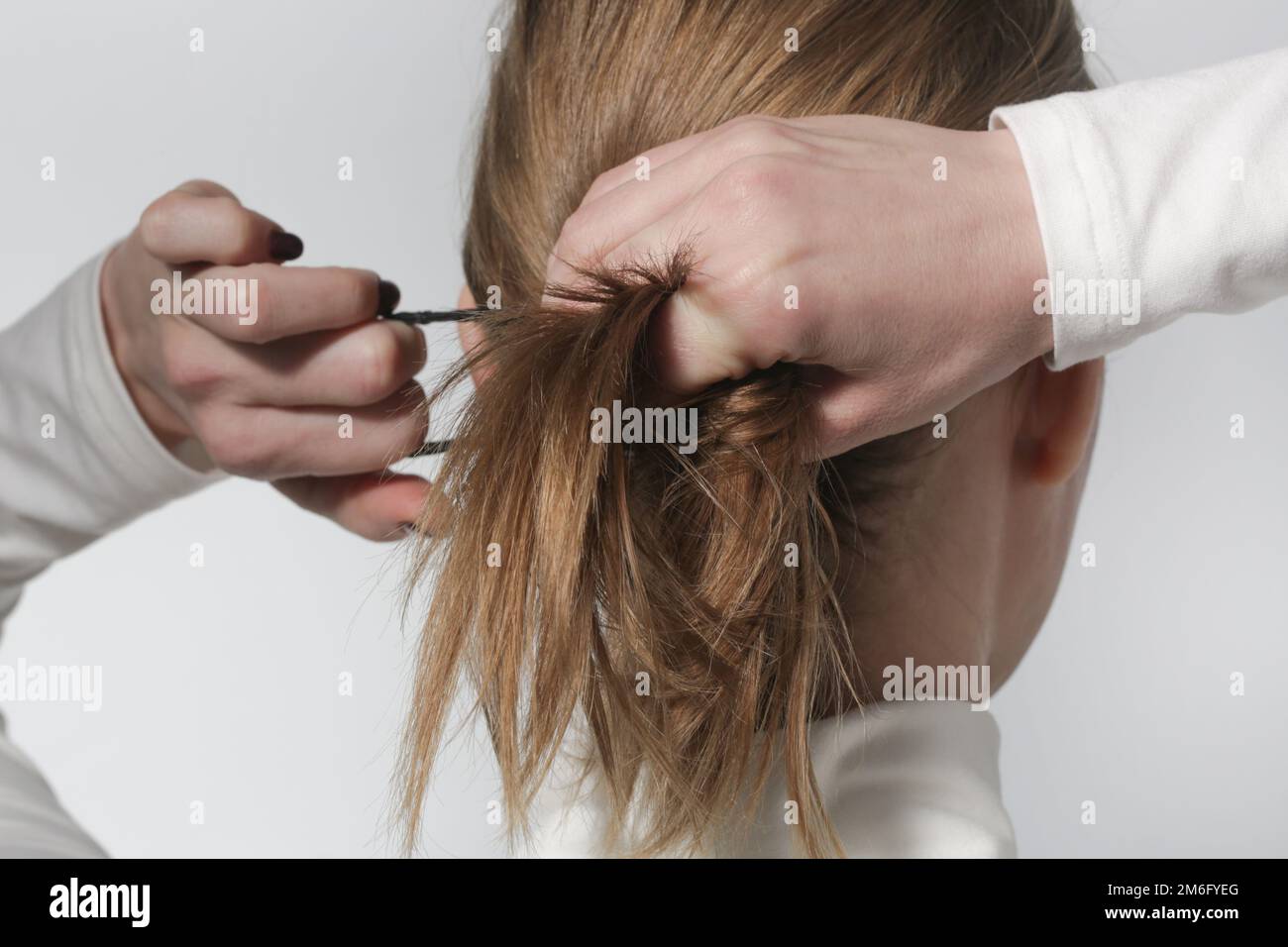 Série de photos de faire une queue de cheval basse avec élastique de base  bande de cheveux. Vue arrière de la jeune femme a attaché ses cheveux dans  la queue de cheval