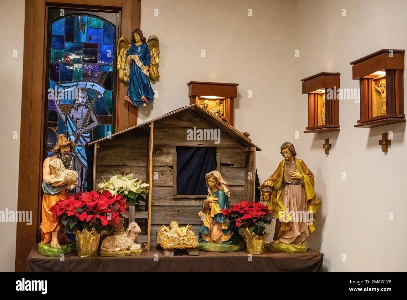 Manger scène avec Marie, Joseph, le bébé Jésus, bergers, animaux et fleurs de poinsettia rouge à Saint Joseph's Catholic Church à Taylors Falls, Minnes Banque D'Images