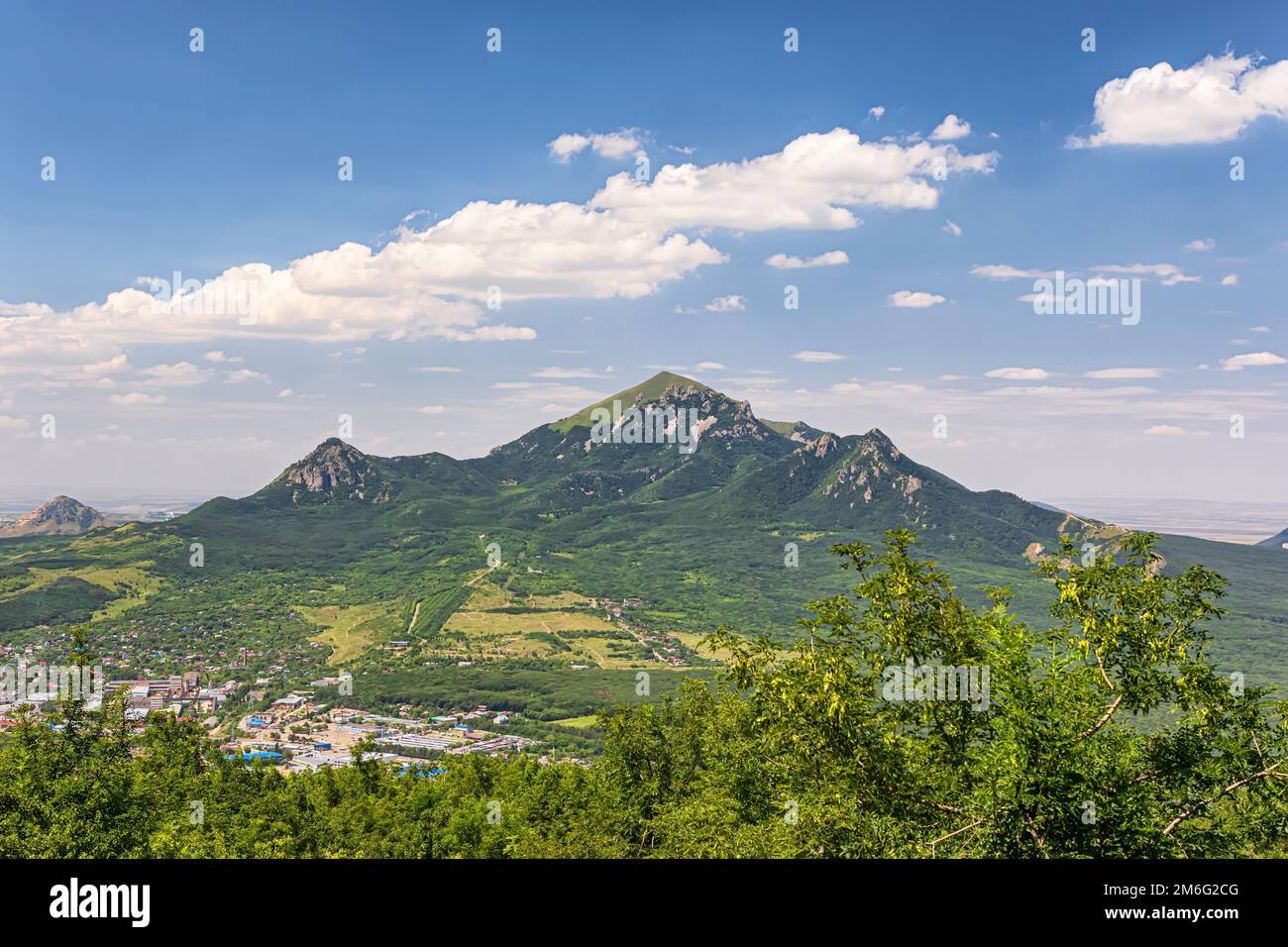 Vue sur la montagne de Beshtau, la ville adjacente de dessous et des nuages moelleux dans le ciel Banque D'Images