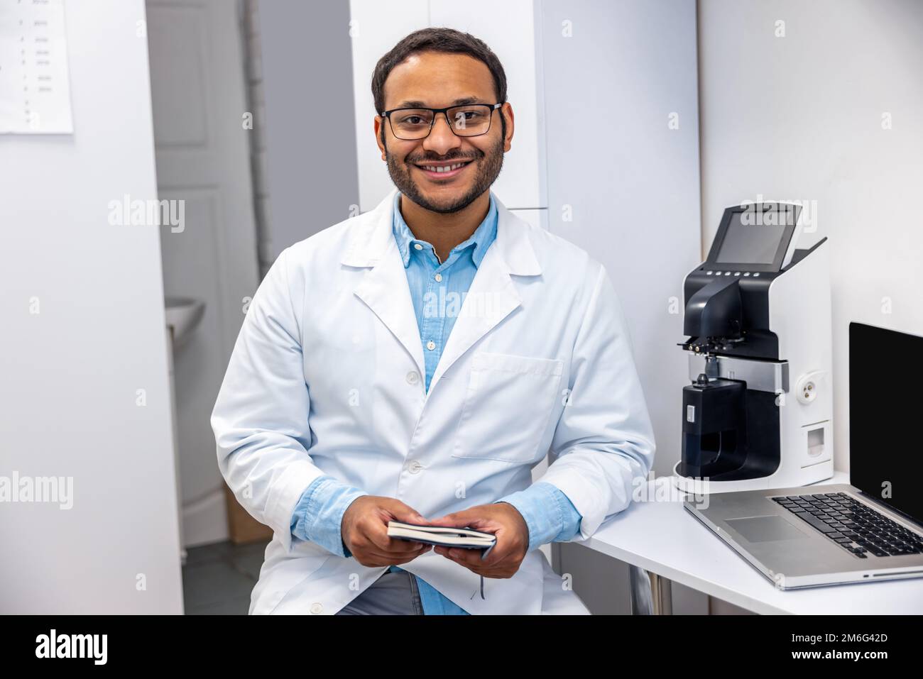 Un médecin de sexe masculin dans des lunettes de vue a l'air positif et amical Banque D'Images