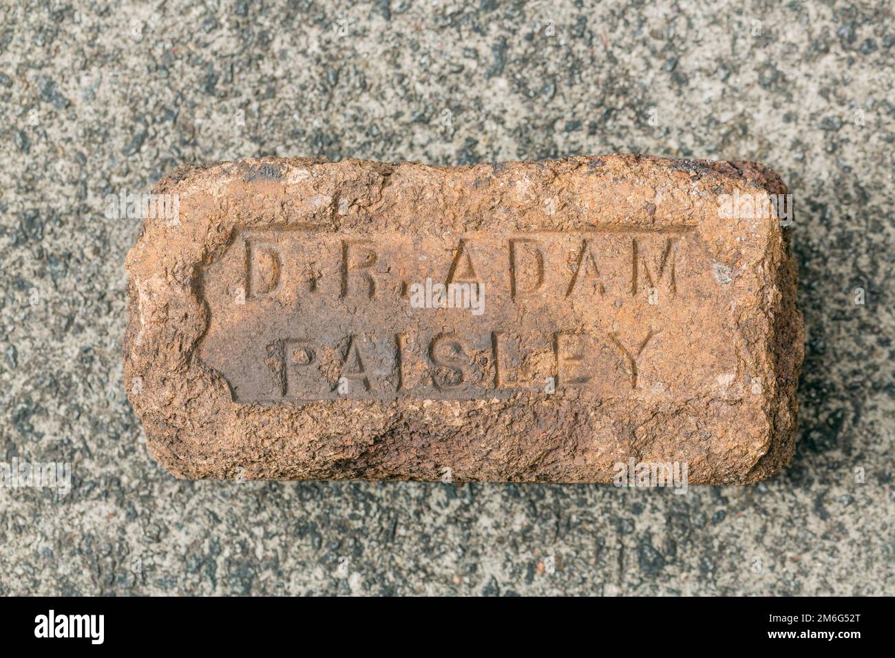 Une vieille brique usée estampillée du nom du fabricant, D R Adam, Paisley, Écosse, Royaume-Uni, Europe Banque D'Images