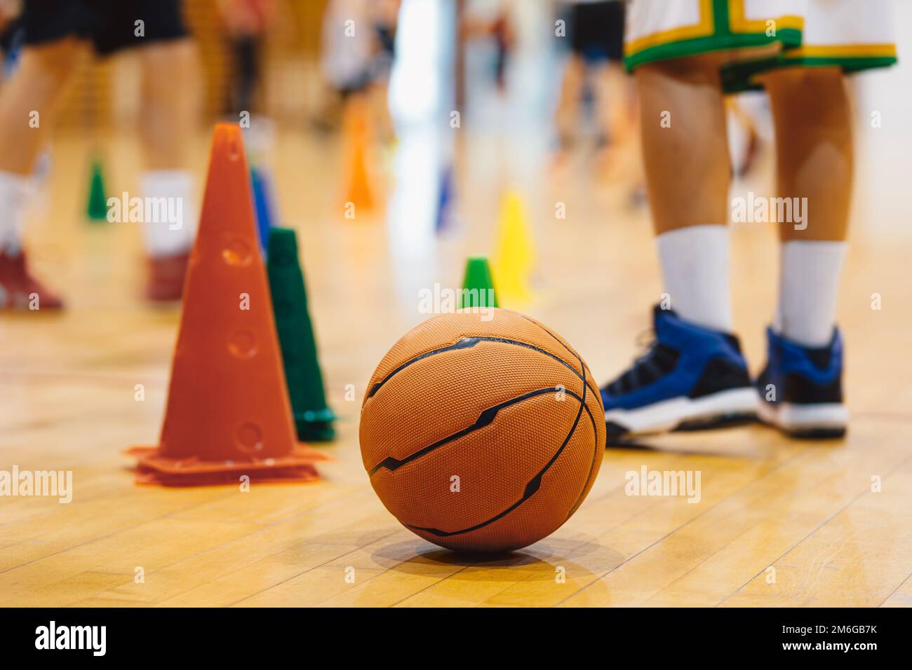 Entraînement de basket-ball junior. Garçons pratiquant le basket-ball lors d'une séance d'entraînement. Basket-ball sur parquet sur le terrain Banque D'Images