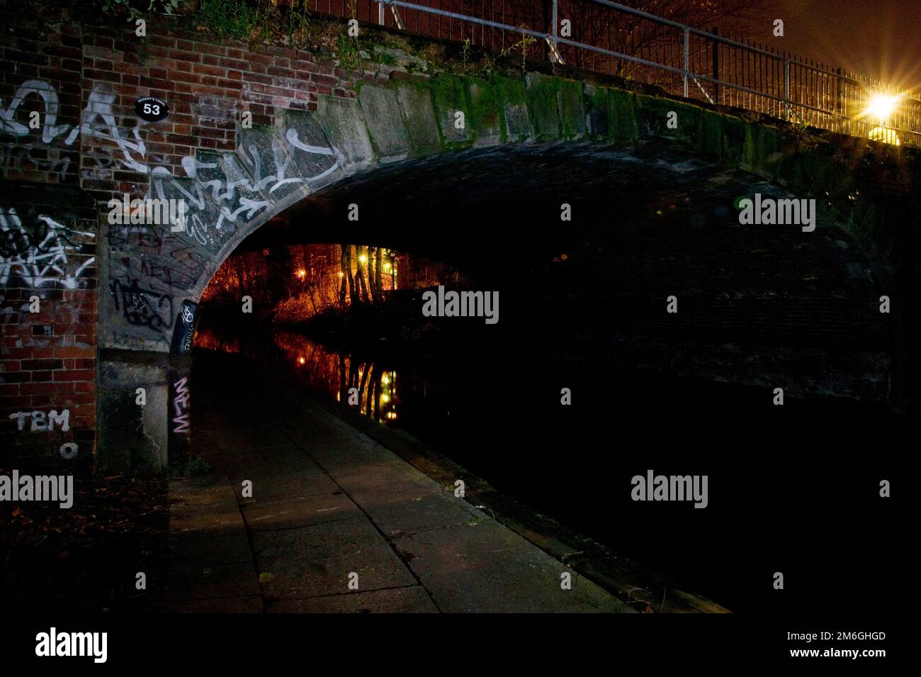 Vue sur un sentier sous un pont sur le canal de Regent la nuit dans le nord de Londres, Camden Banque D'Images