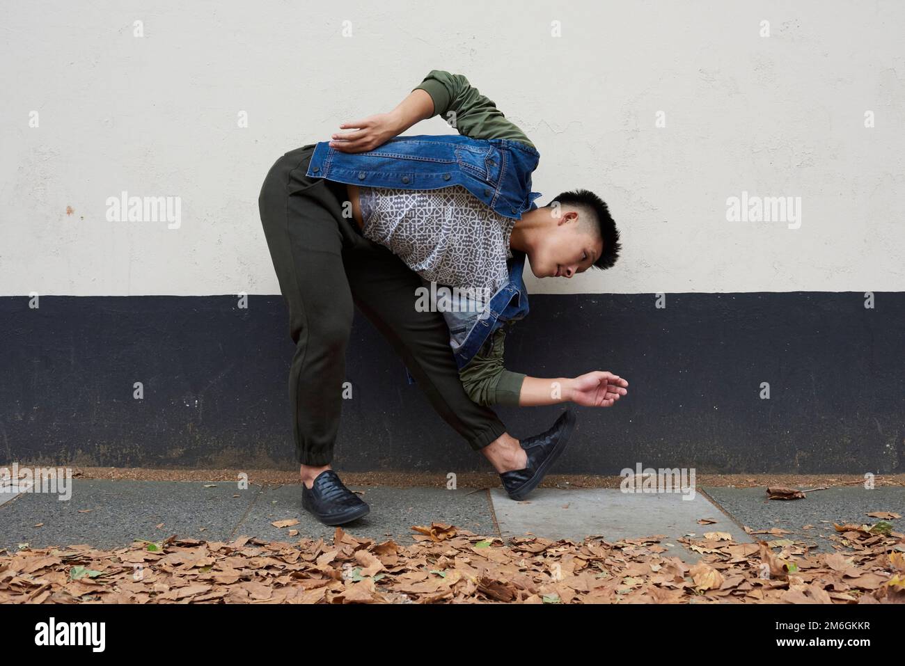 Un jeune danseur asiatique se déplace dans une rue de Londres Banque D'Images