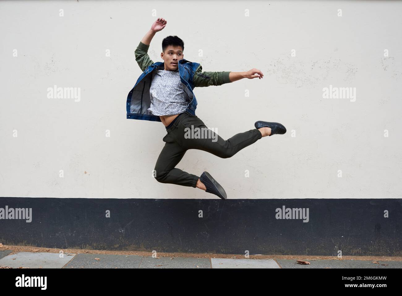 Un jeune danseur asiatique se déplace dans une rue de Londres Banque D'Images