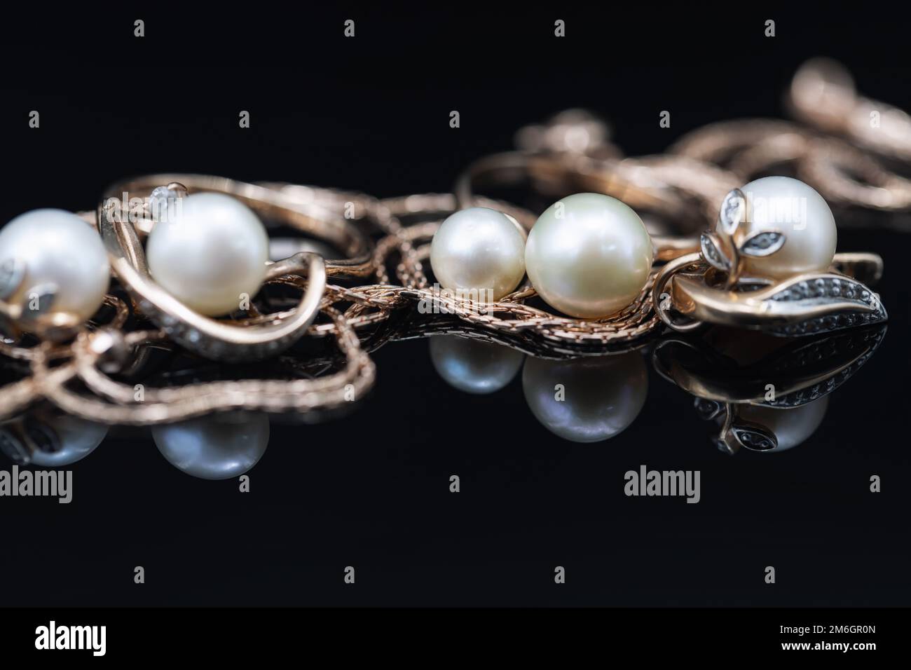 Boucles d'oreilles et bagues dorées ornées de perles blanches Banque D'Images