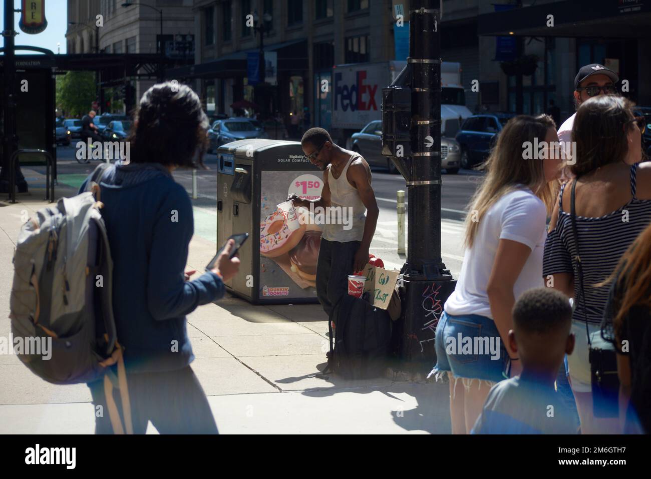 Un homme noir supplie le changement et les dons du public au soleil sur un coin de rue dans la zone du parc du Millénaire de Chicago en été Banque D'Images