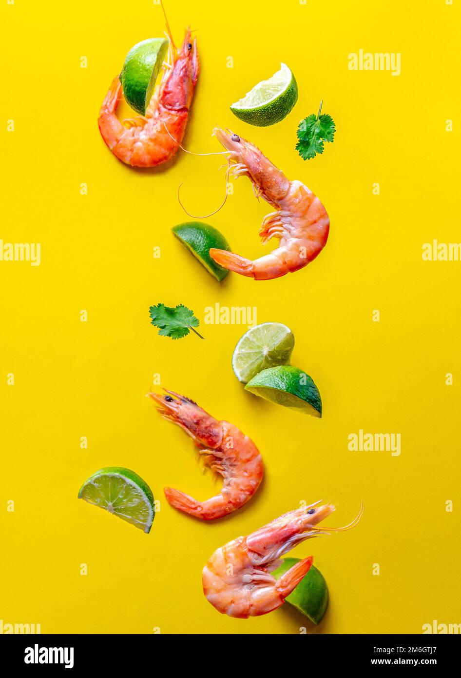 Nourriture volante. Crevettes de fruits de mer aux crevettes avec cilantro et fond jaune citron. Banque D'Images