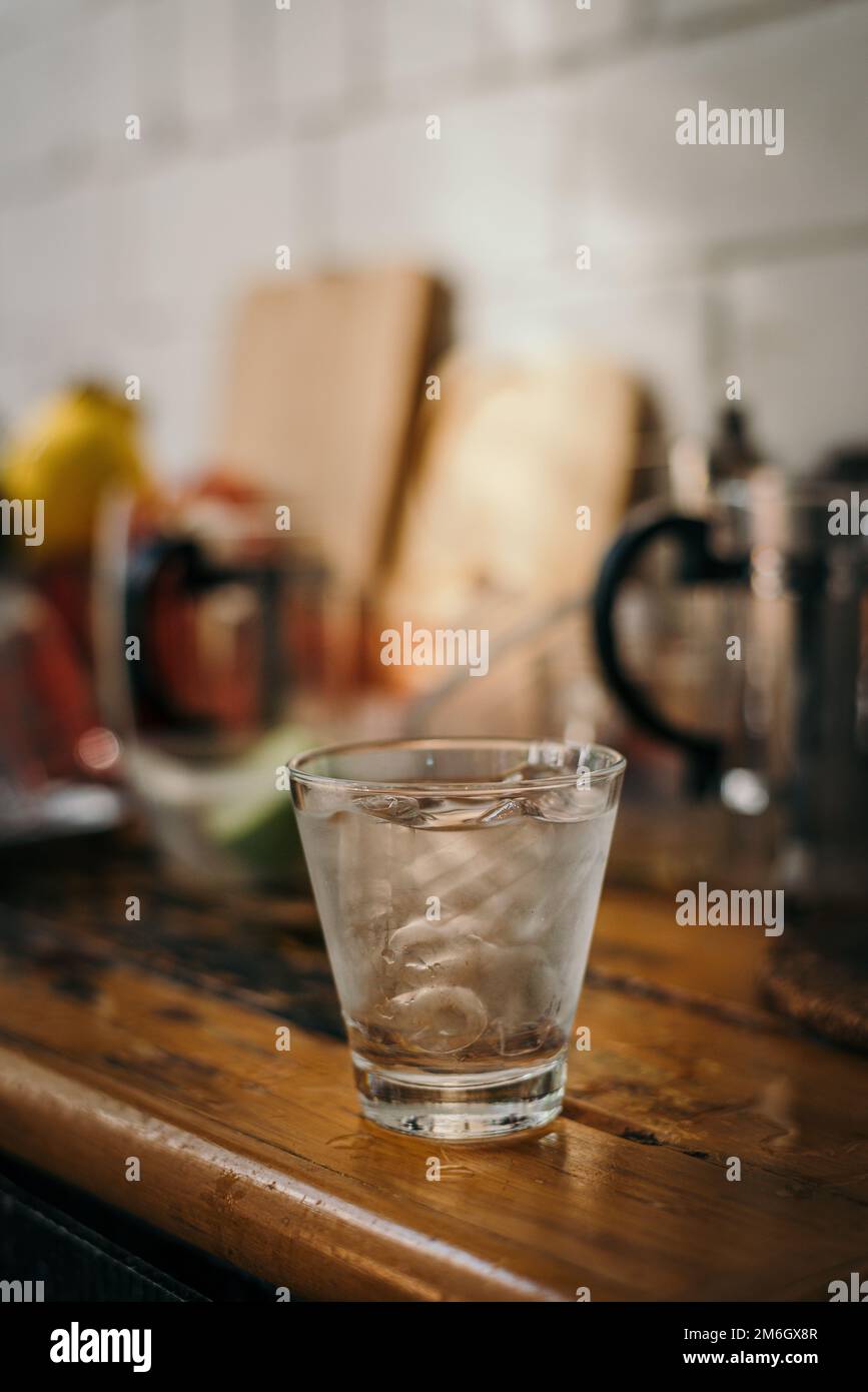 Verre d'eau glacée avec vaisselle de cuisine floue Banque D'Images