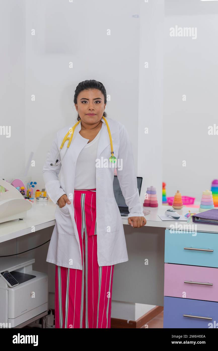 portrait d'un médecin pédiatre dans son bureau, avec robe et stéthoscope. Banque D'Images