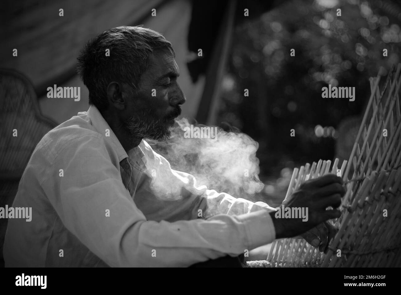 Vadodara, Gujarat - 19 novembre 2022: Homme indien âgé gros plan visage avec peau ridée et cheveux gris bon et beau visage fumant Banque D'Images