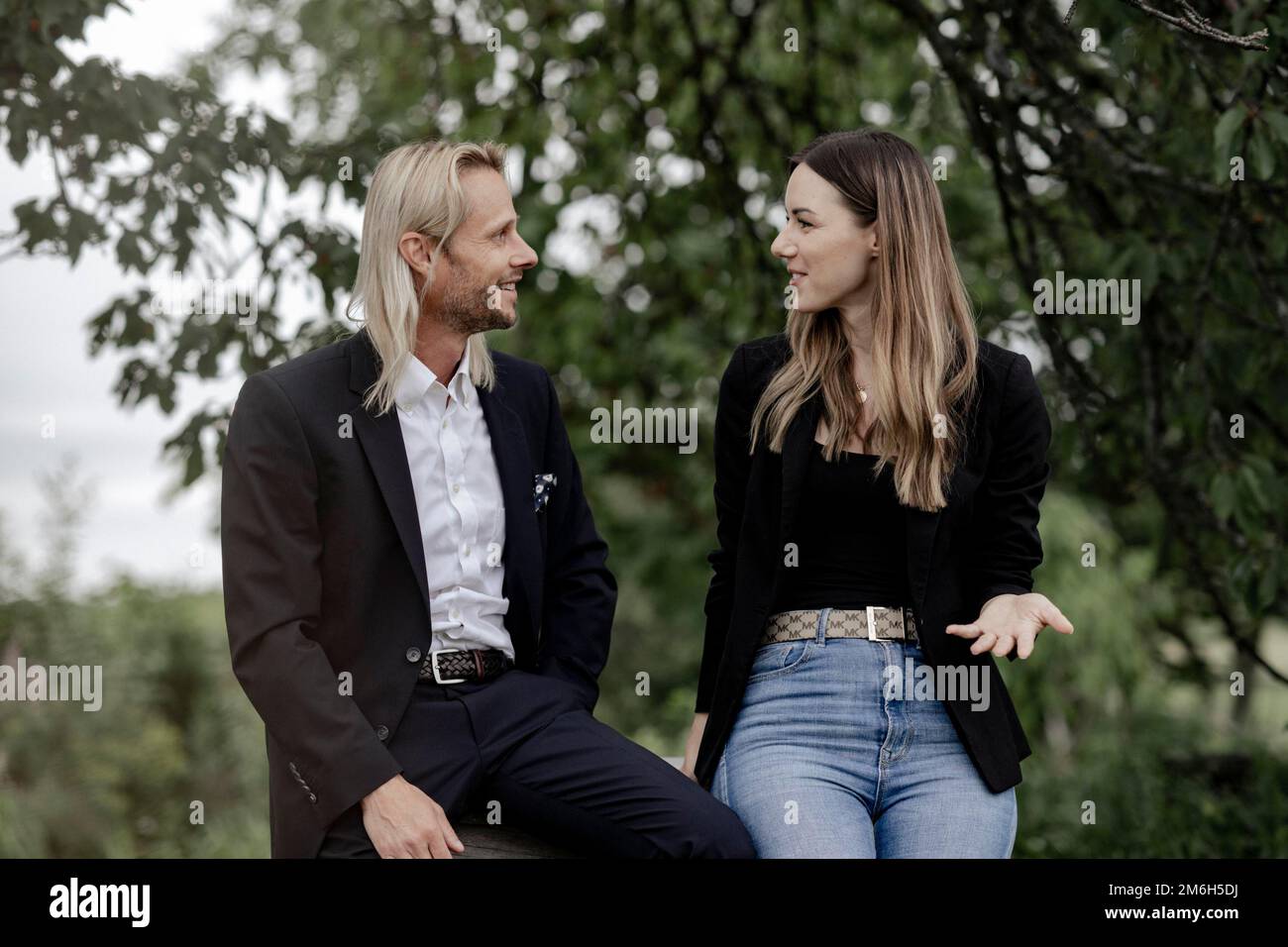 Homme et femme parlant sur une table en bois dans la nature Banque D'Images
