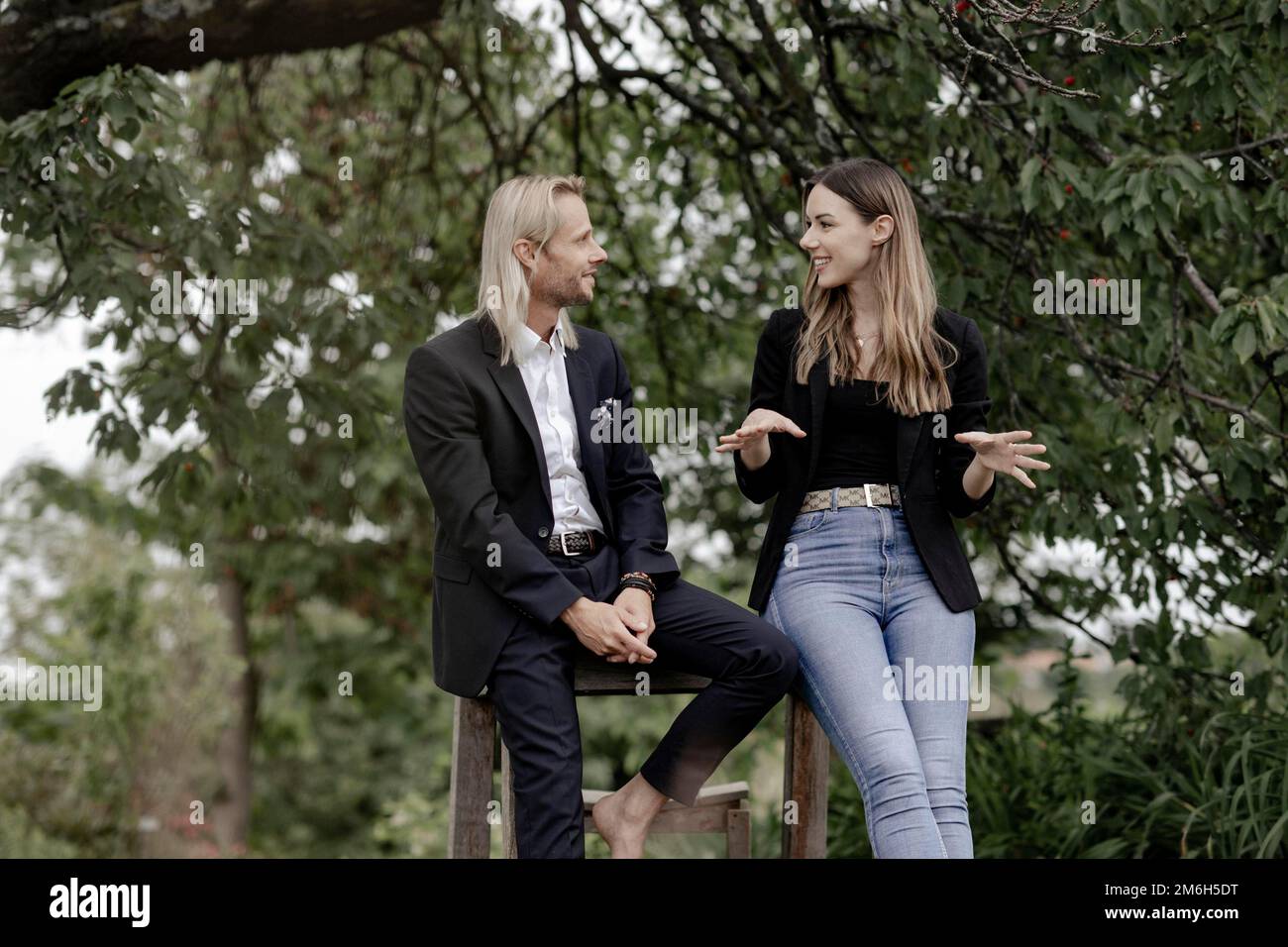 Homme et femme parlant sur une table en bois dans la nature Banque D'Images