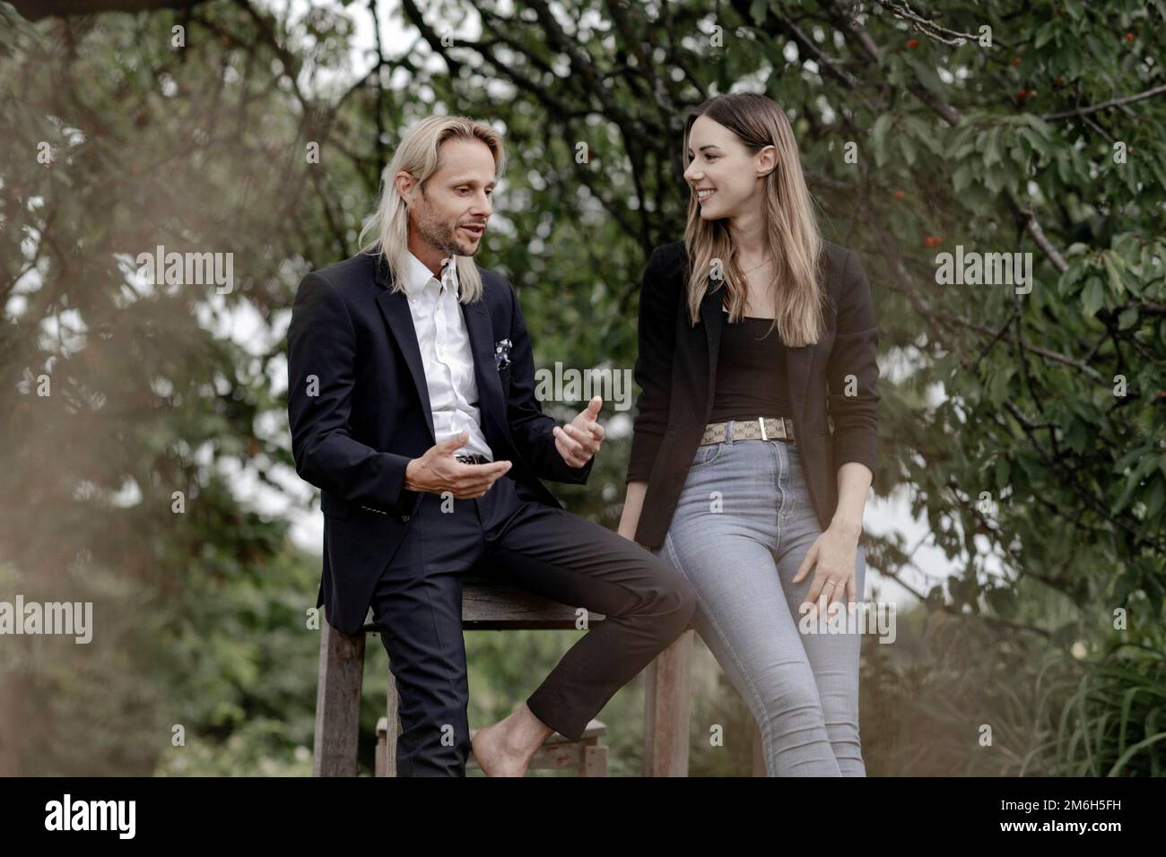 Homme et femme parlant sur une table en bois dans la nature Banque D'Images