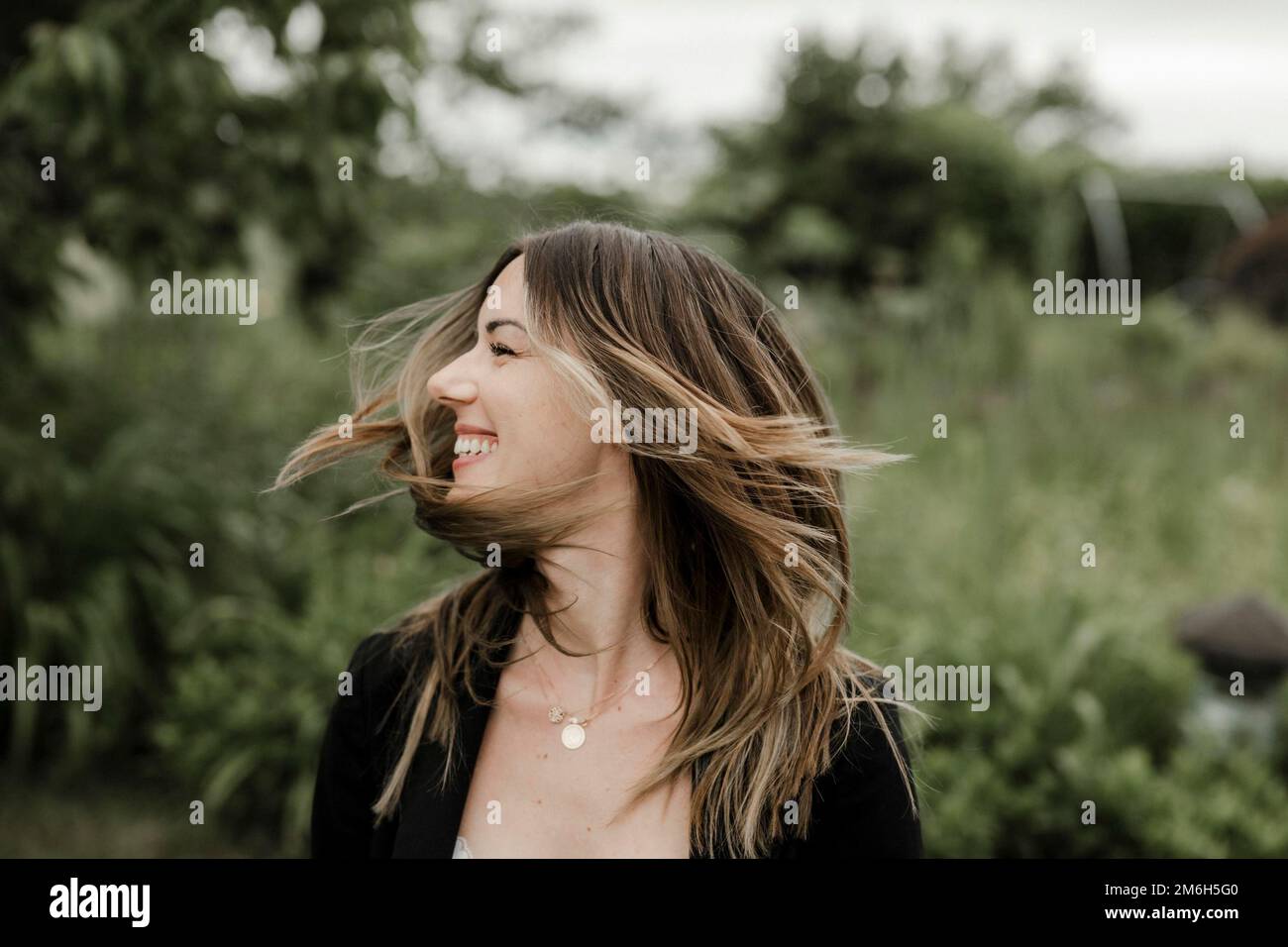 Rire jeune femme en portrait, 25, avec des cheveux volants Banque D'Images