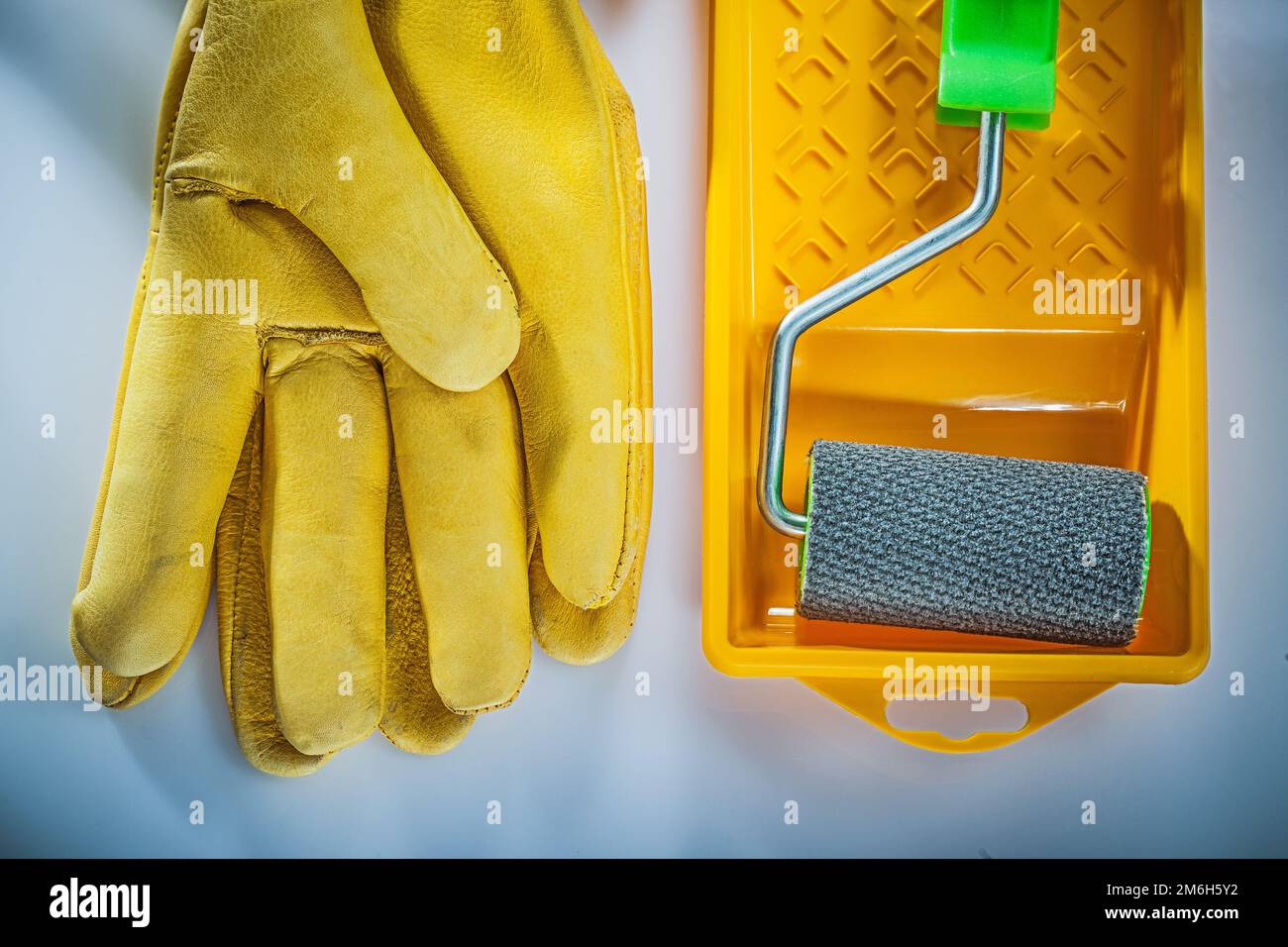 Gants de protection en cuir peint rouleau de plateau sur fond blanc. Banque D'Images