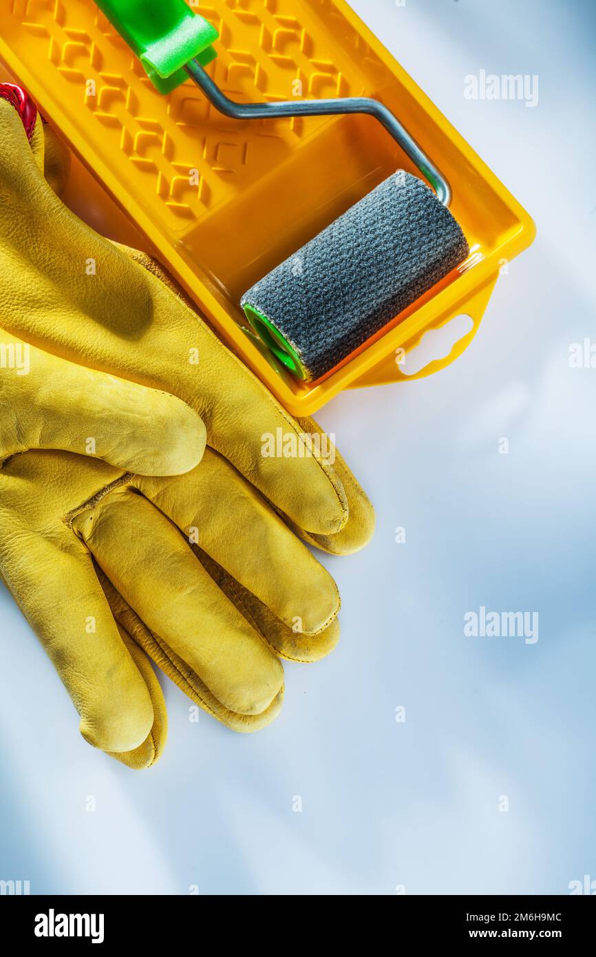 Jeu de gants de protection en cuir peint rouleau de plateau sur fond blanc. Banque D'Images