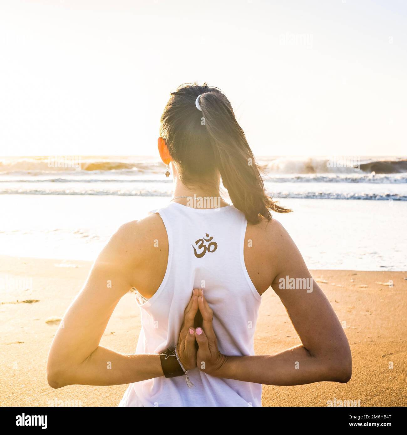 Photo d'une jeune femme pratiquant le yoga à la plage Banque D'Images