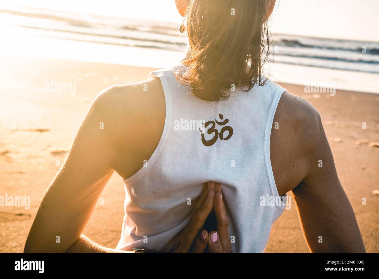 Photo d'une jeune femme pratiquant le yoga à la plage Banque D'Images