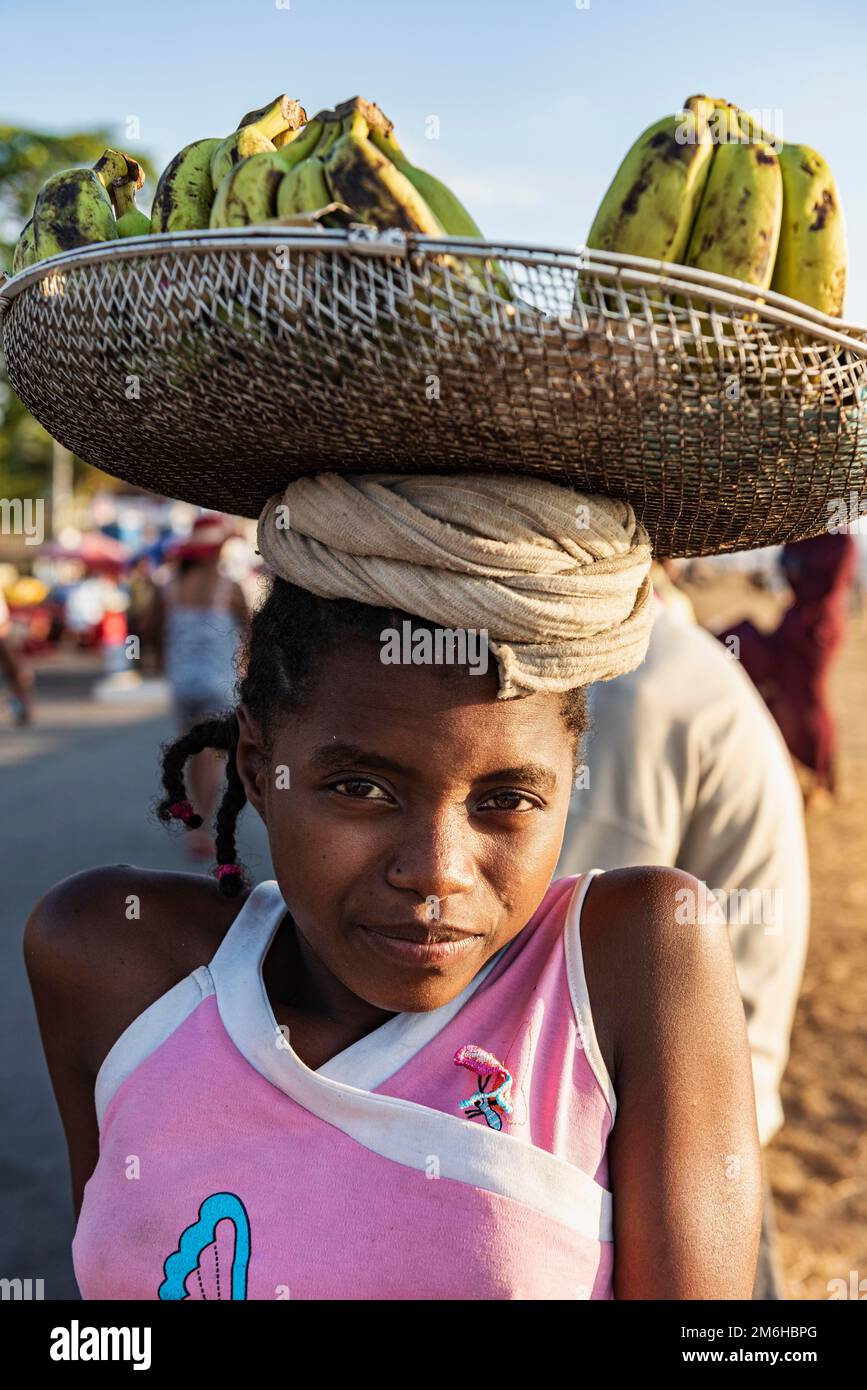Fille avec charge de tête, panier avec bananes, charge, Mahajanga, Madagascar Banque D'Images