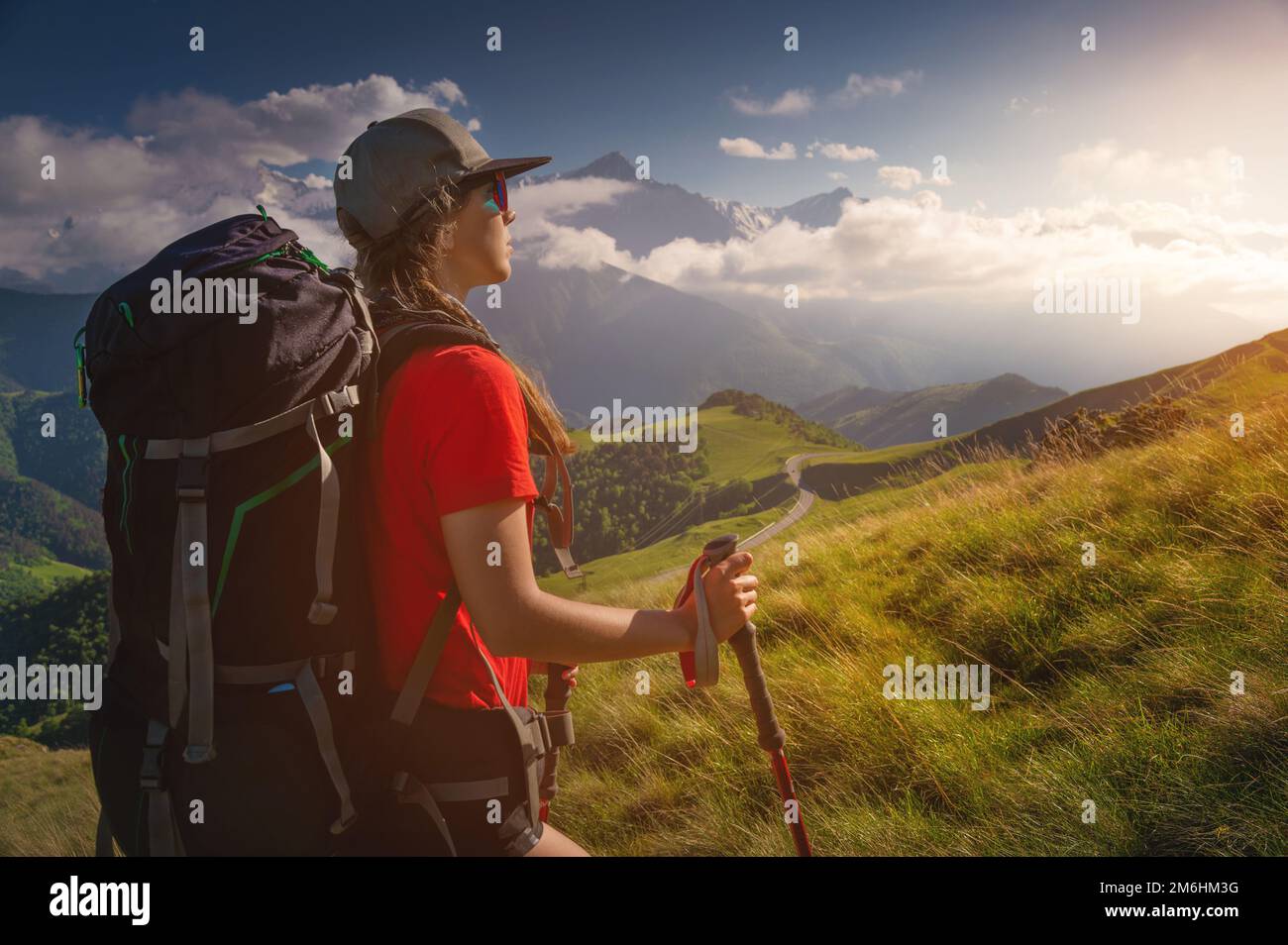 Femme touriste jeune caucasien marchant en amont sur une journée ensoleillée sous la lumière du soleil. Belle vue sur le paysage de montagne. Trek attrayant Banque D'Images