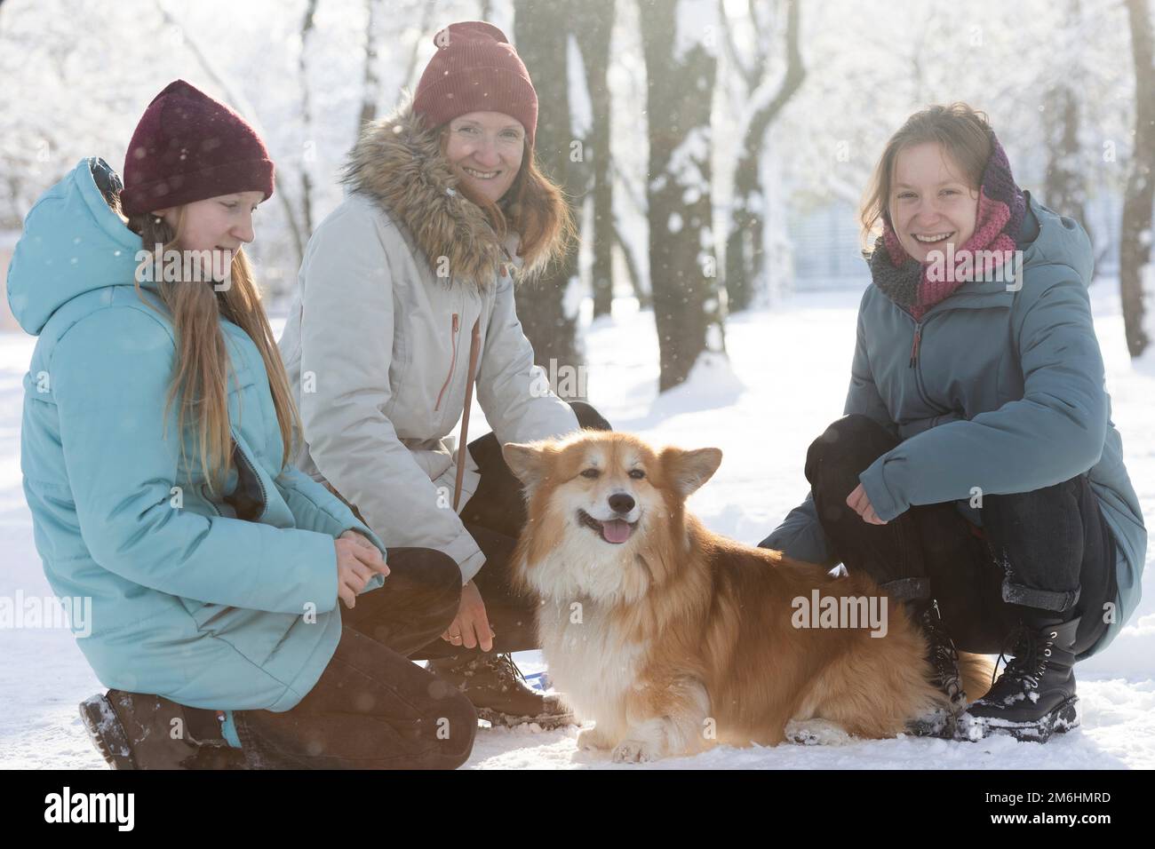 famille heureuse - maman, filles et chien de corgi dans le parc d'hiver Banque D'Images