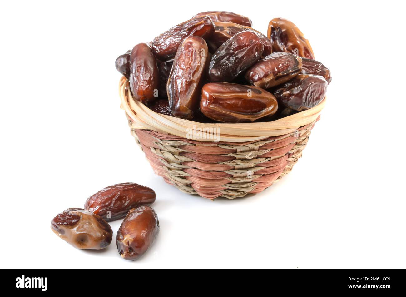 Dates dans un panier sur fond blanc avec une ombre molle Banque D'Images