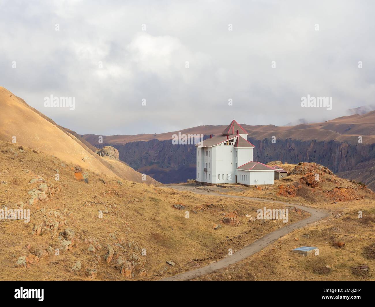 Haut dans les montagnes près de la falaise se dresse une maison blanche avec des fenêtres étroites donnant sur le haut plateau de montagne du Cauca Banque D'Images