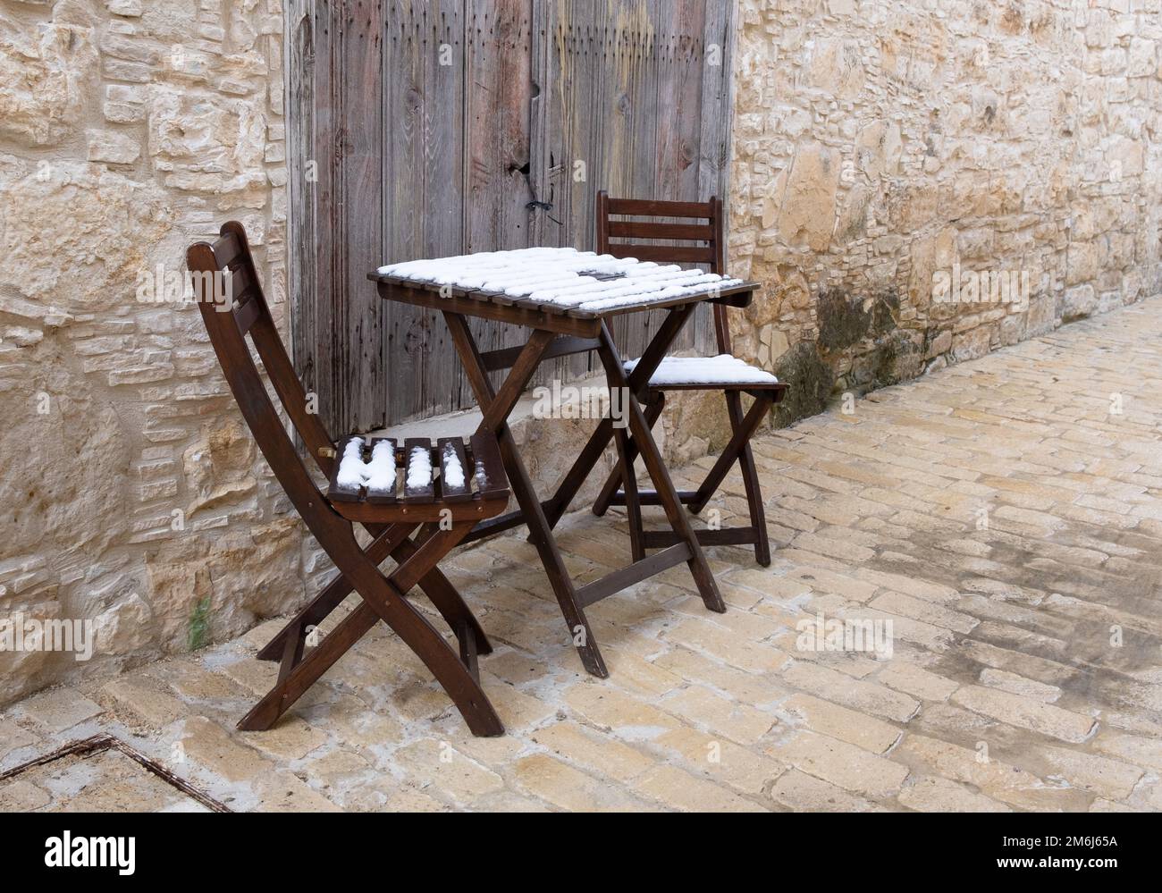 Vider les chaises en bois recouvertes de neige et la table basse sur un sentier laqué. Banque D'Images
